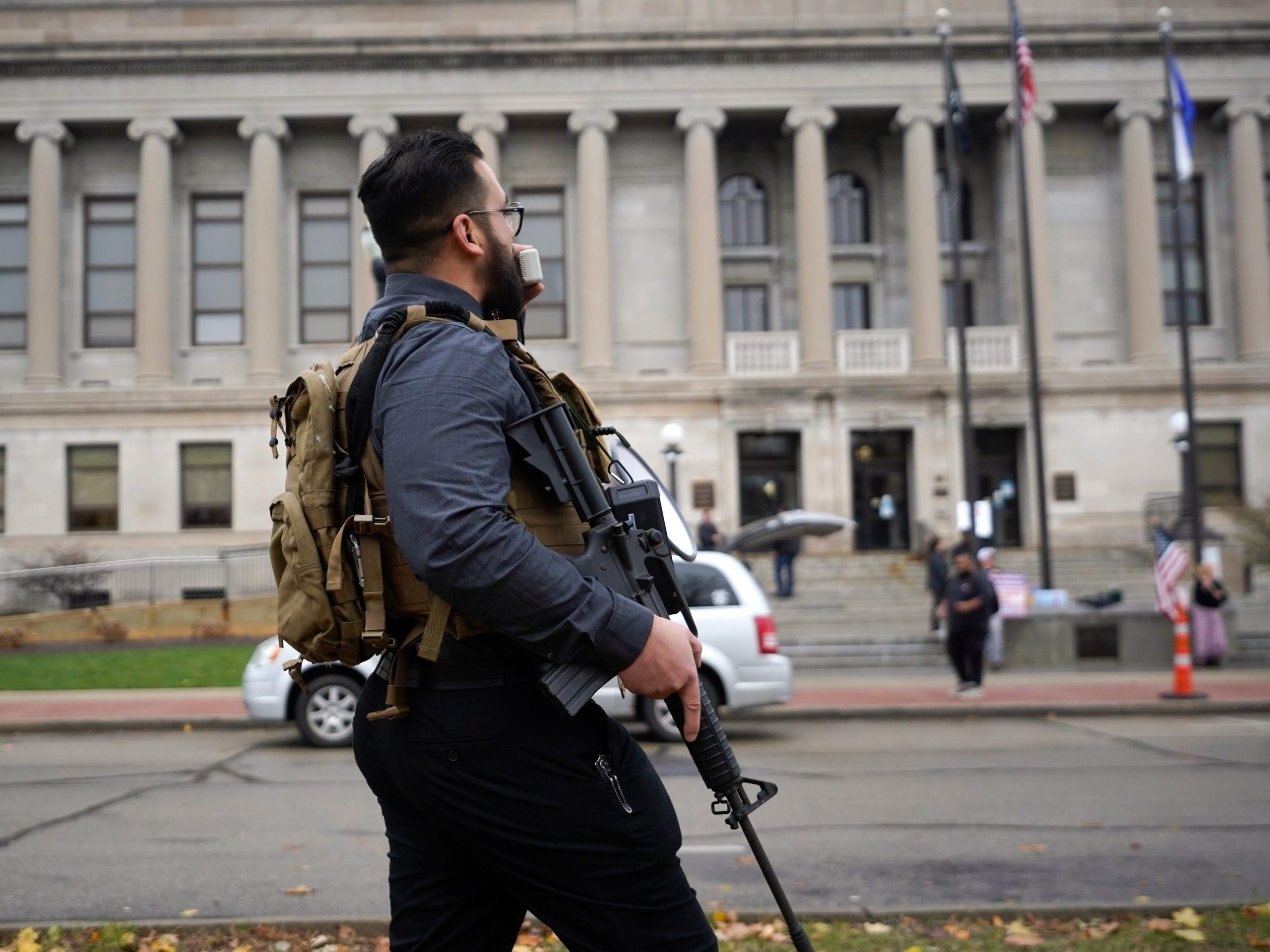 A protester carries a rifle outside the Kenosha County Courthouse, Wednesday, Nov. 17, 2021 in Kenosha, Wis., during the Kyle Rittenhouse murder trial.