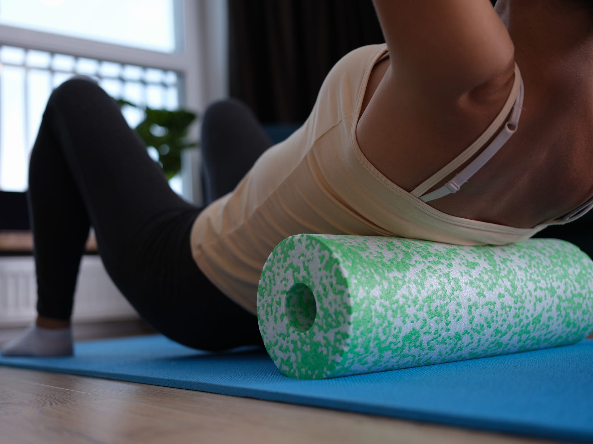 a person using a foam roller on their mid-back