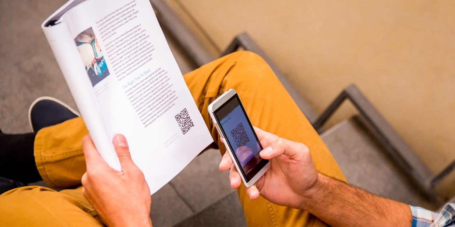 Man scanning QR Code in magazine