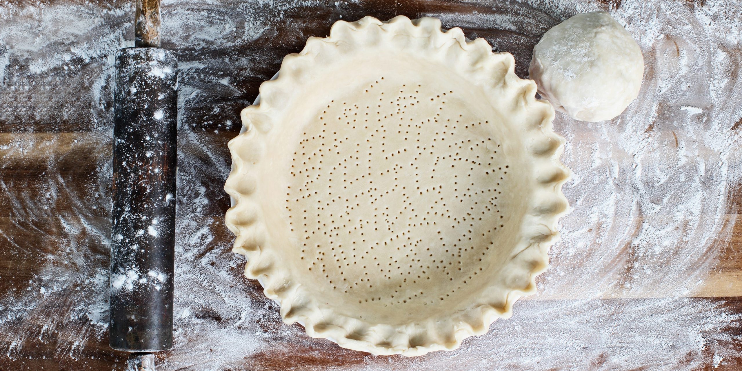 A top view of an unbaked docked pie crust