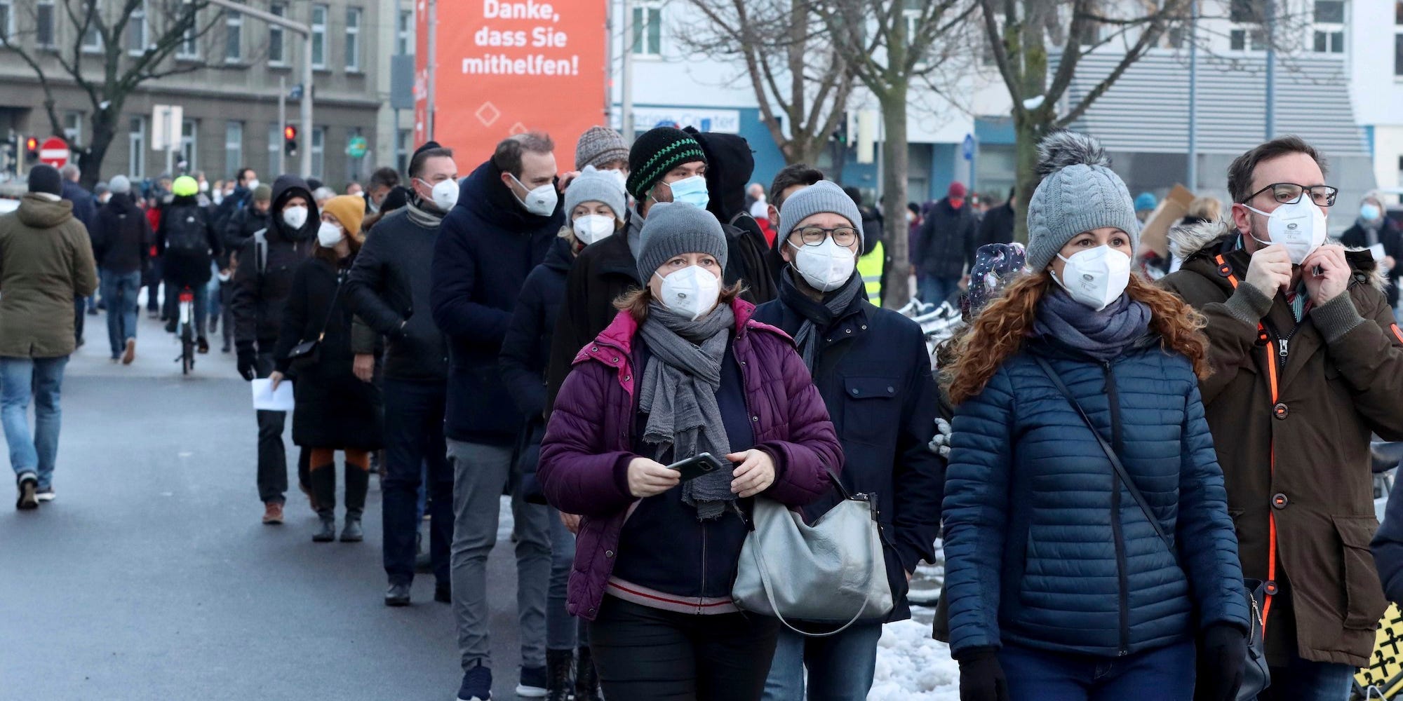 People wearing masks queue in Austria