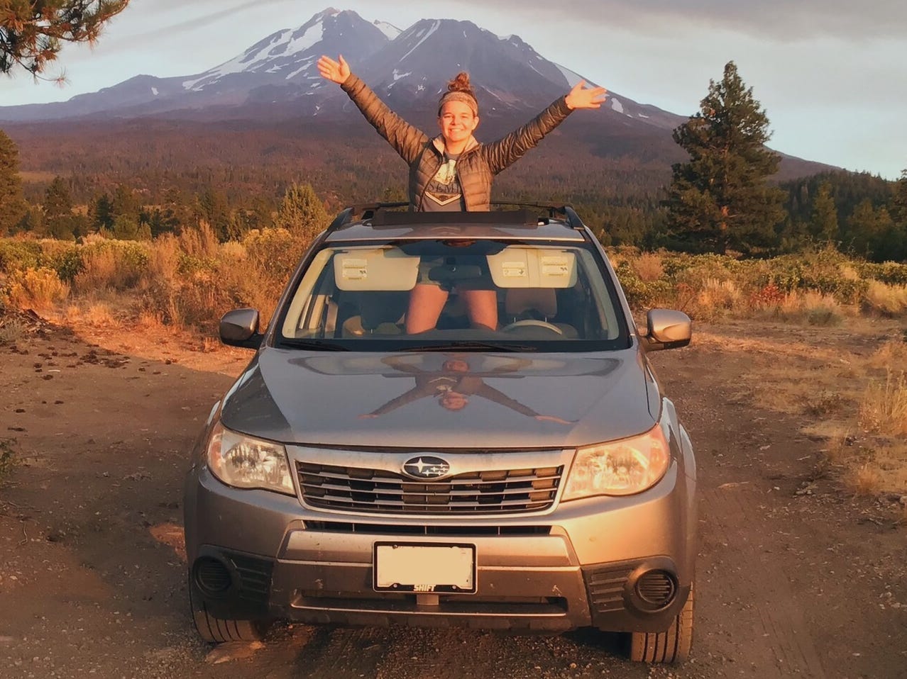 nicole standing thorugh the sunroof of her subaru forester