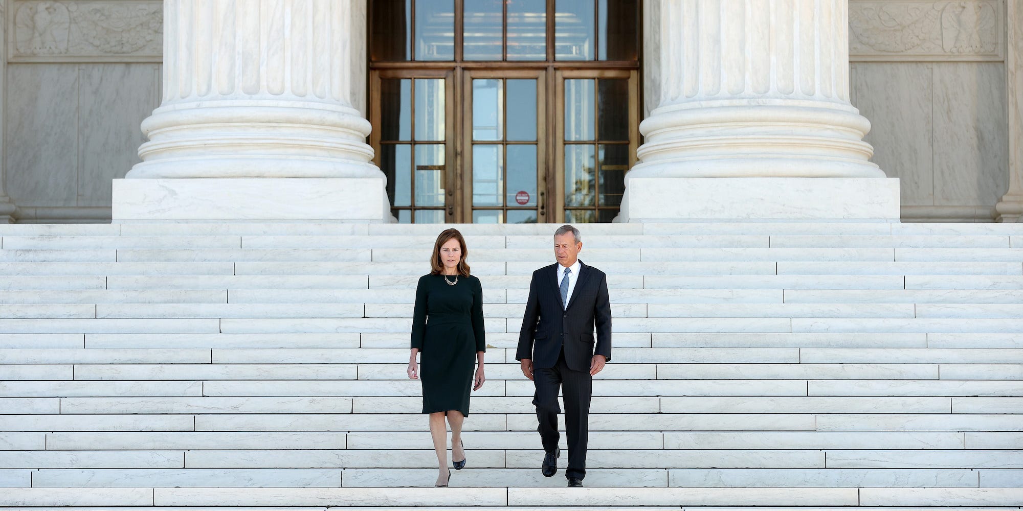 Supreme Court Associate Justice Amy Coney Barrett and Chief Justice John Roberts walk down the steps of the west side of the Supreme Court following her investiture ceremony on October 01, 2021.