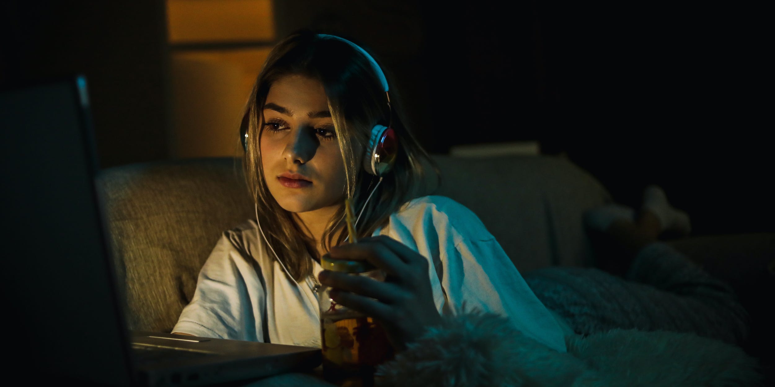 woman watching movie on laptop headphones