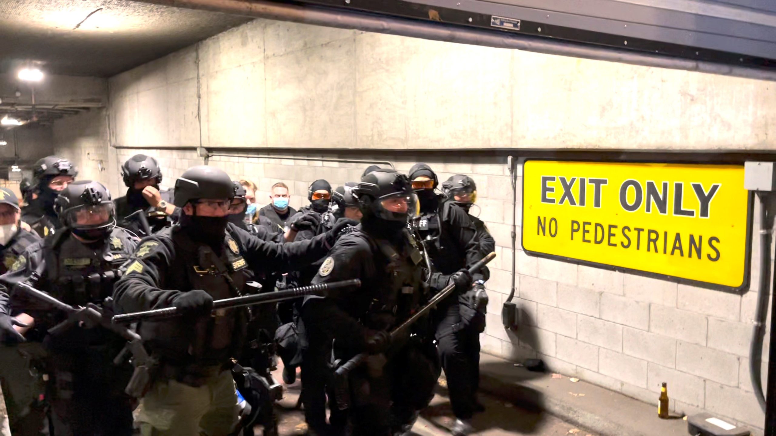 Members of the police in riot gear stand in a garage during a confrontation with protesters after the "not guilty" verdict was announced in the trial of Kyle Rittenhouse, in Portland, Oregon, U.S., November 19, 2021.