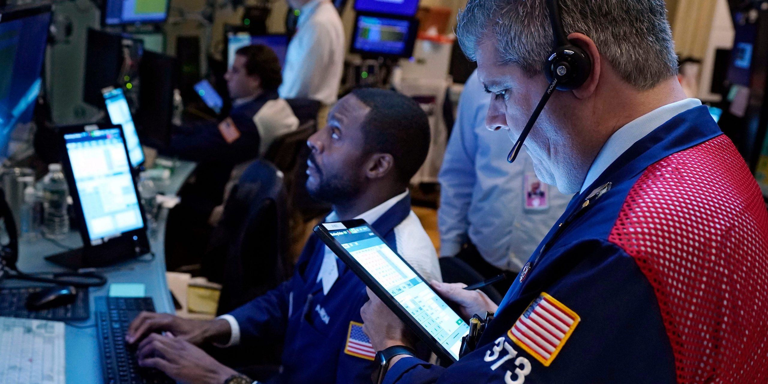 Two traders work on the floor of the New York Stock Exchange