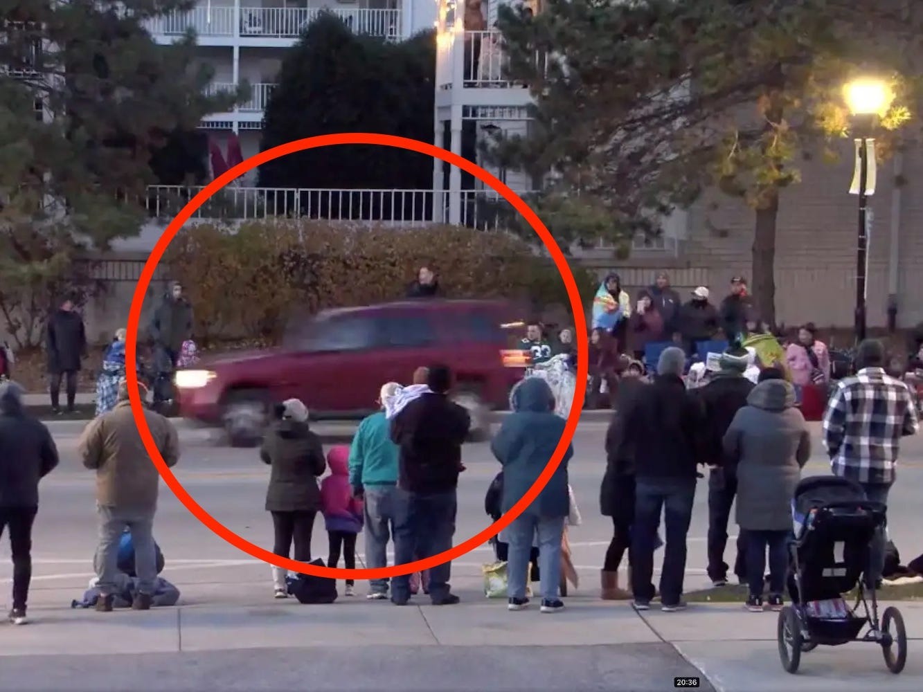 A red car, circled, moving at speed in front of parade-goers in Waukesha, Wisconsin, November 21 2021