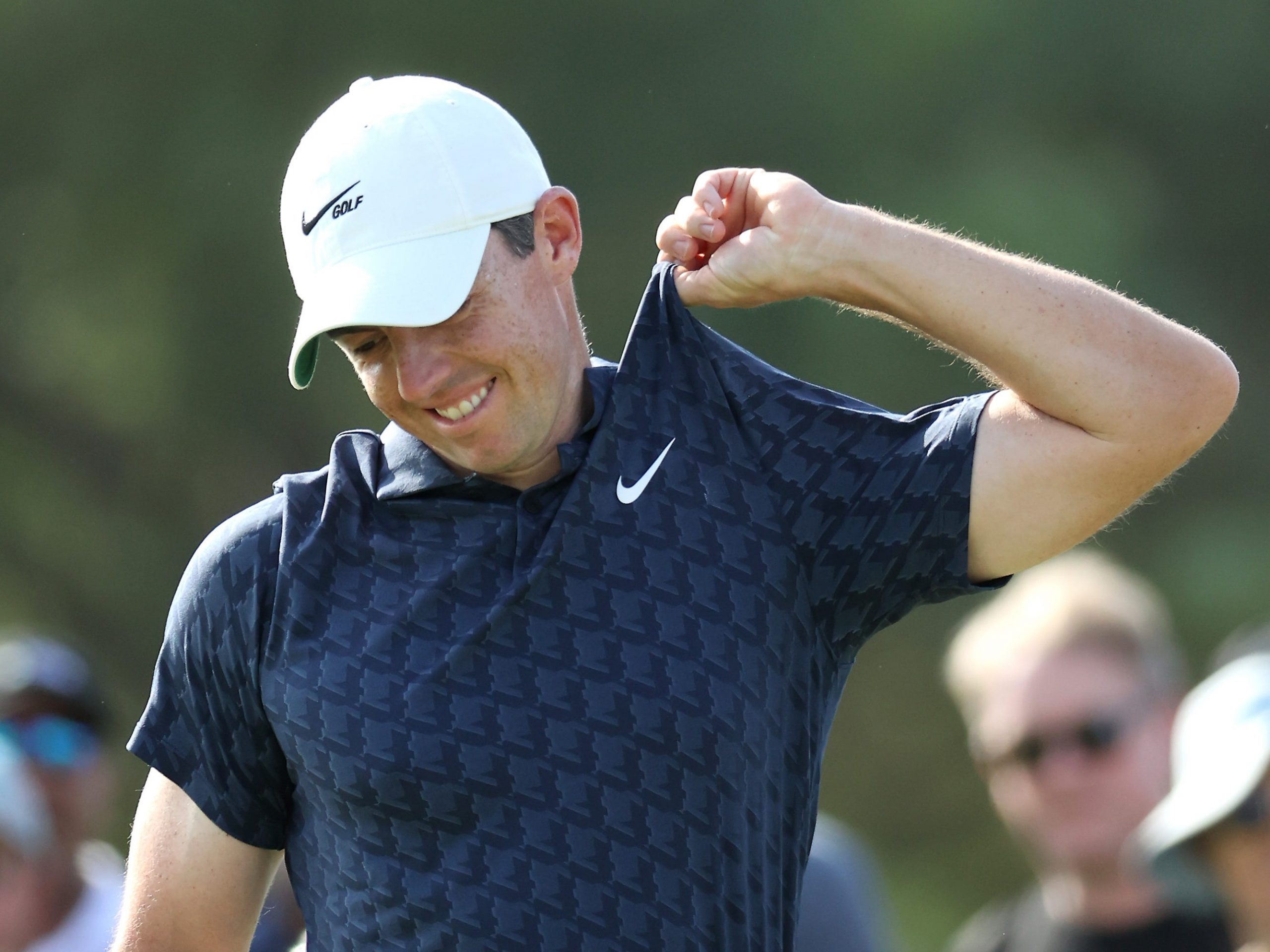 Rory McIlroy tugs his shirt.