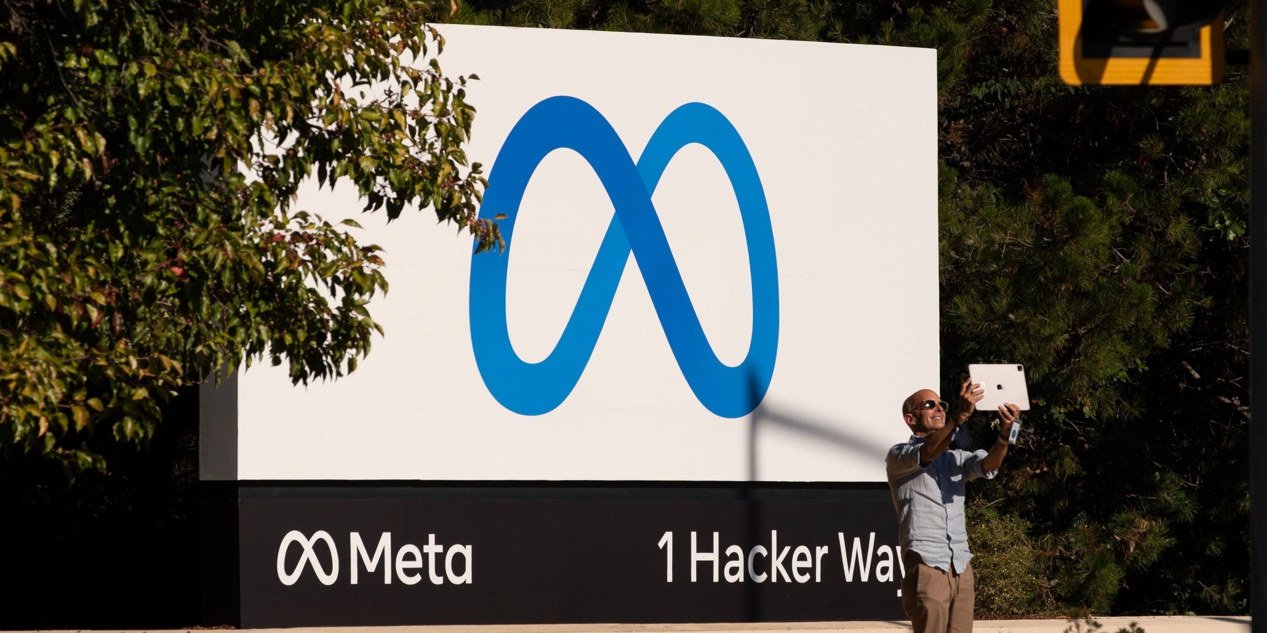 A man takes pictures in front of a sign showing logo of Meta outside Facebook headquarters on October 28, 2021 in Menlo Park, California.