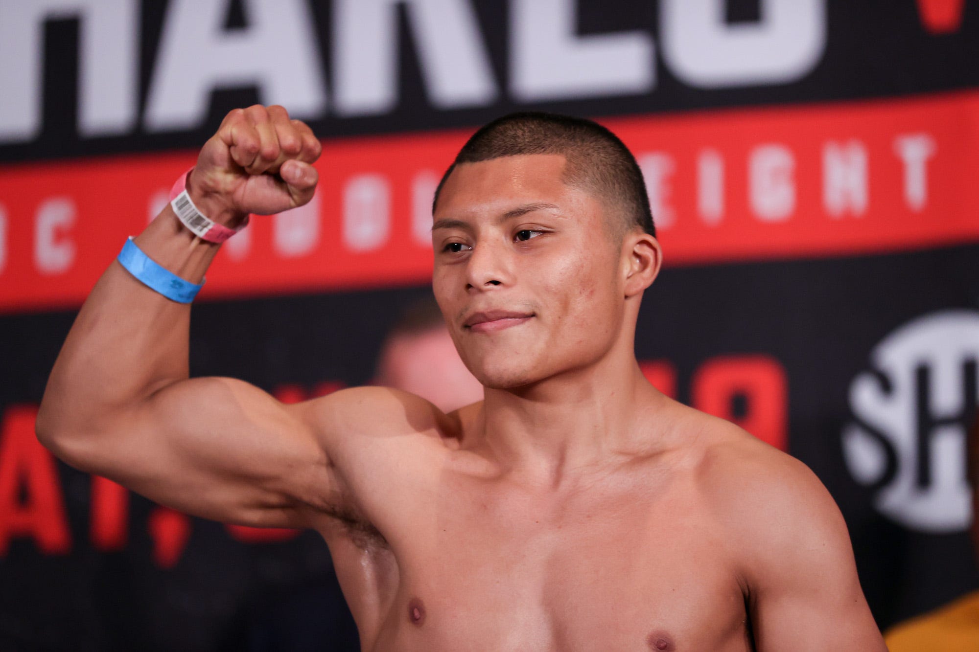 Isaac Cruz flexes during a pre-fight event.