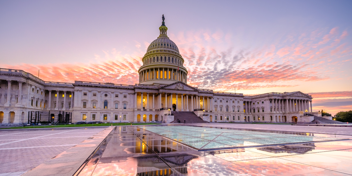 Far out image of the capitol building with a pink and purple sky overhead.