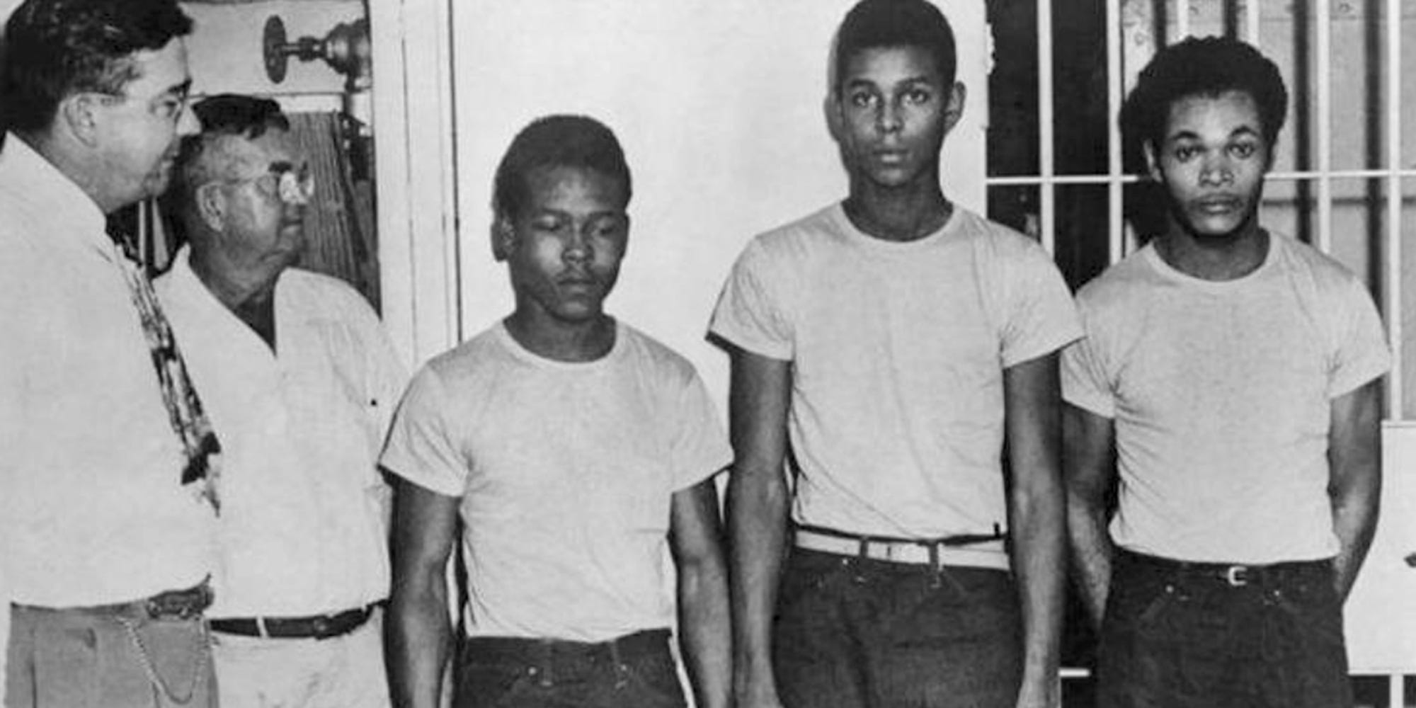 A Black and white image showing three Black men, the sheriff, and another man.