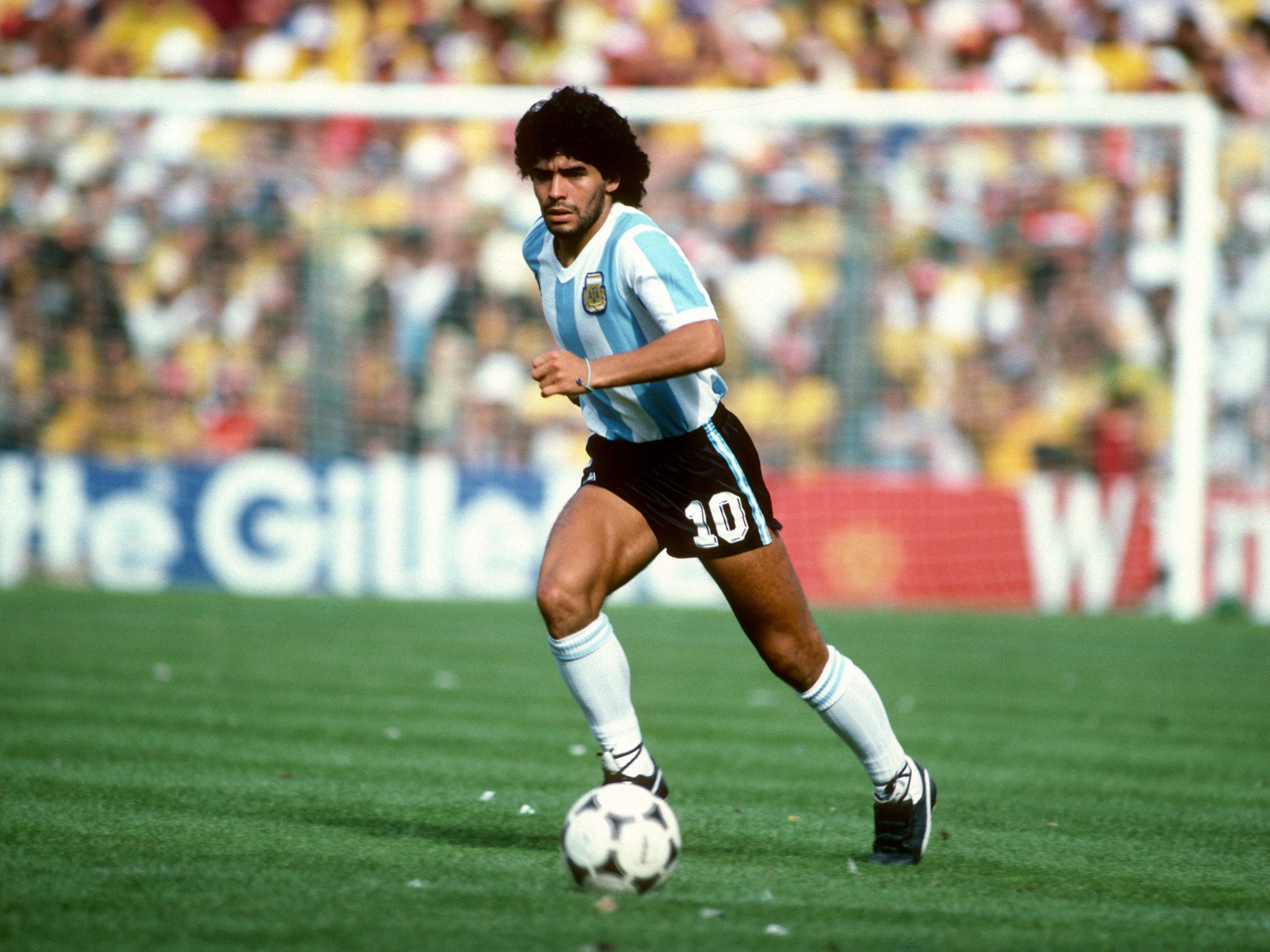 Diego Maradona dribbles with the ball.