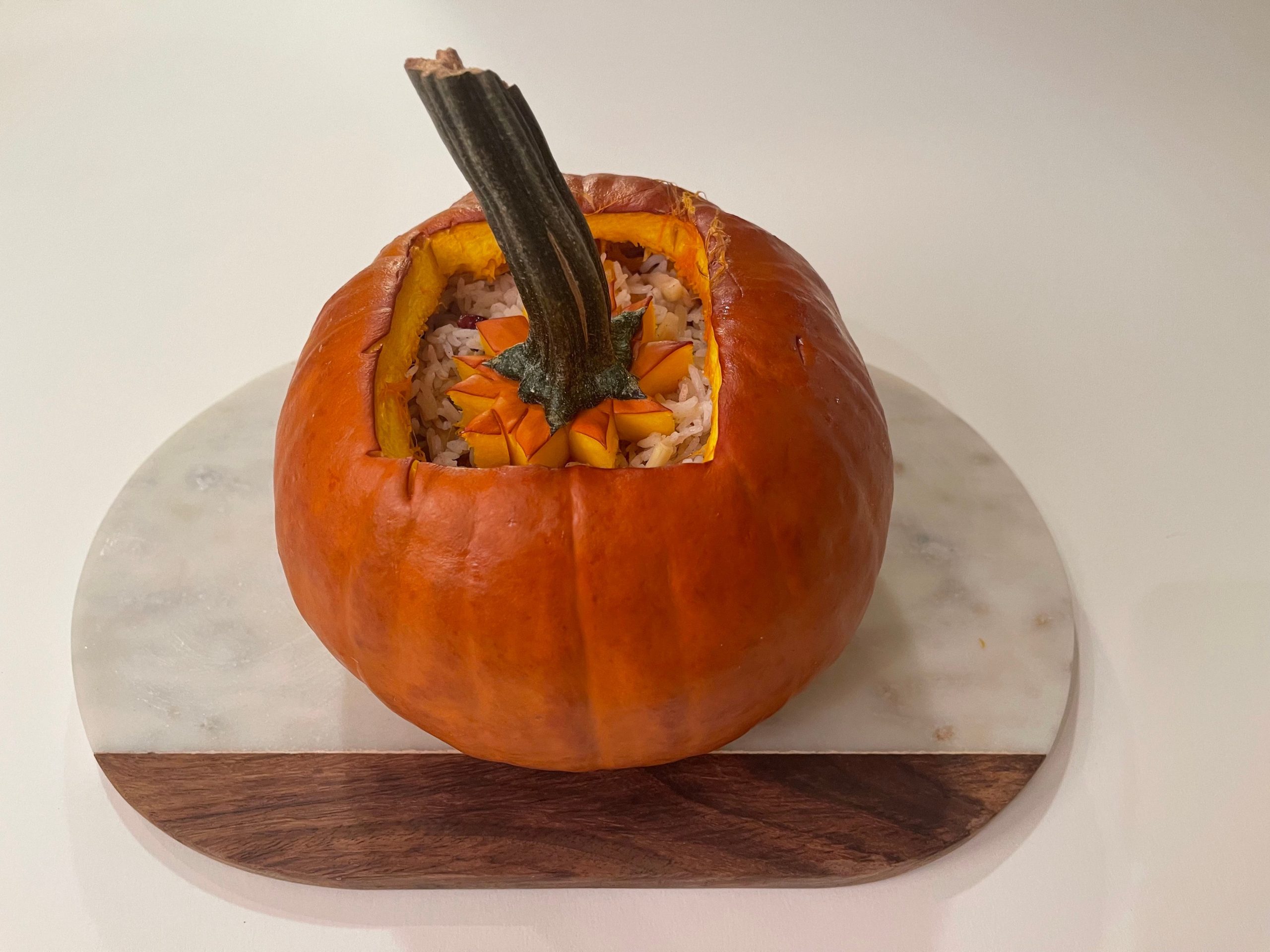 A baked pumpkin on a marble cutting board.