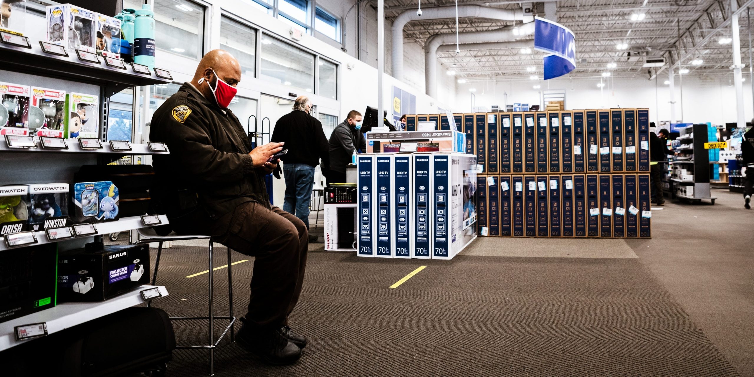 A police officer wears a mask while sitting on guard at a Best Buy in Kentucky.