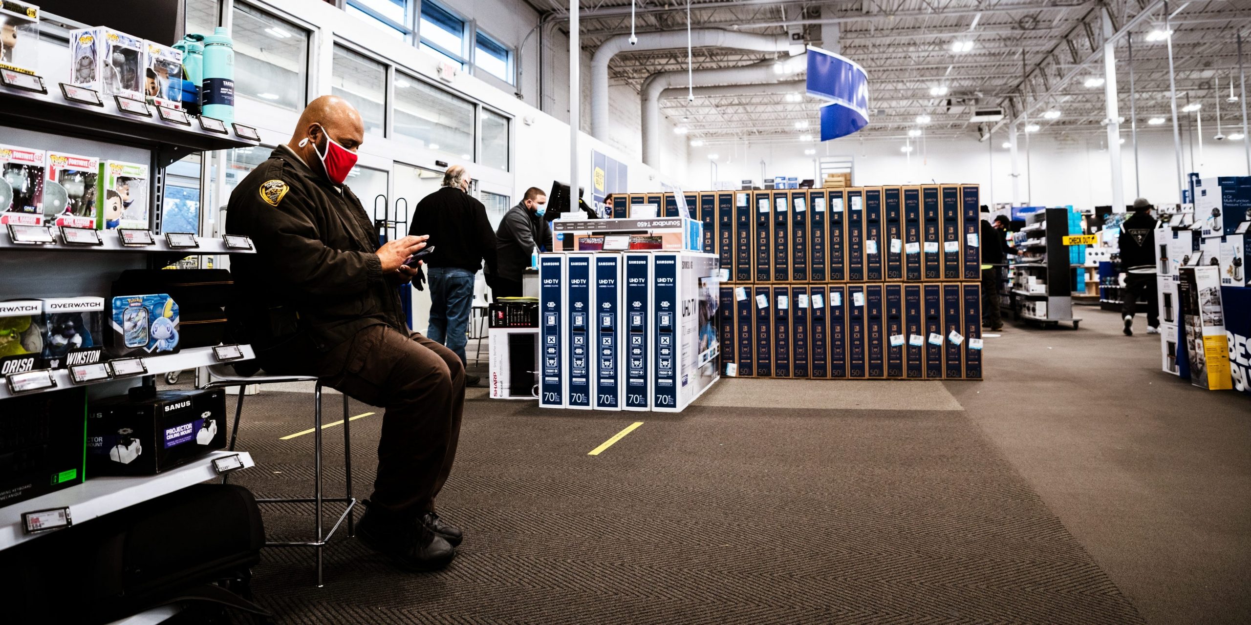 A police officer wears a mask while sitting on guard at a Best Buy in Kentucky.