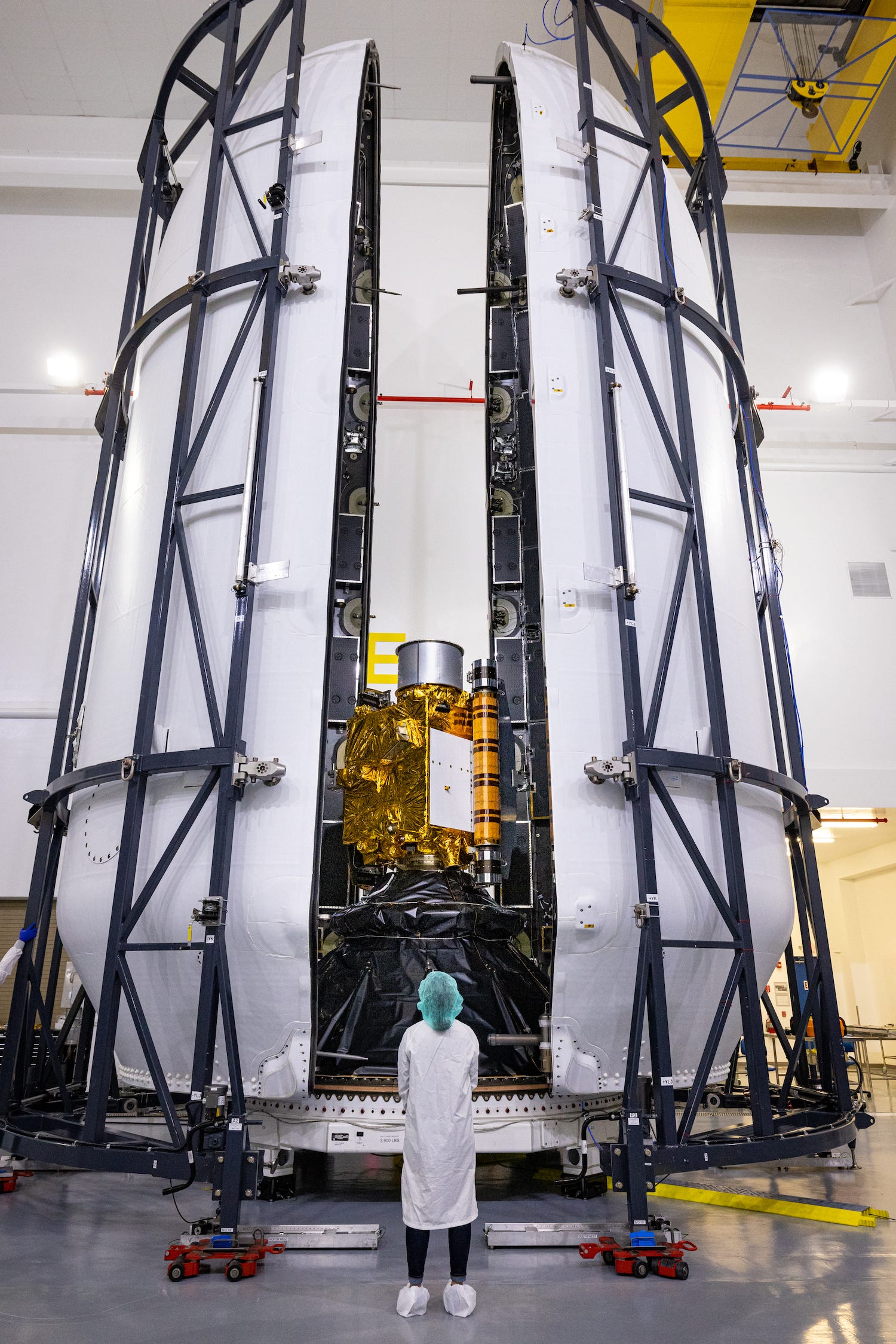 rocket fairing two large halves close around small human-sized dart spacecraft
