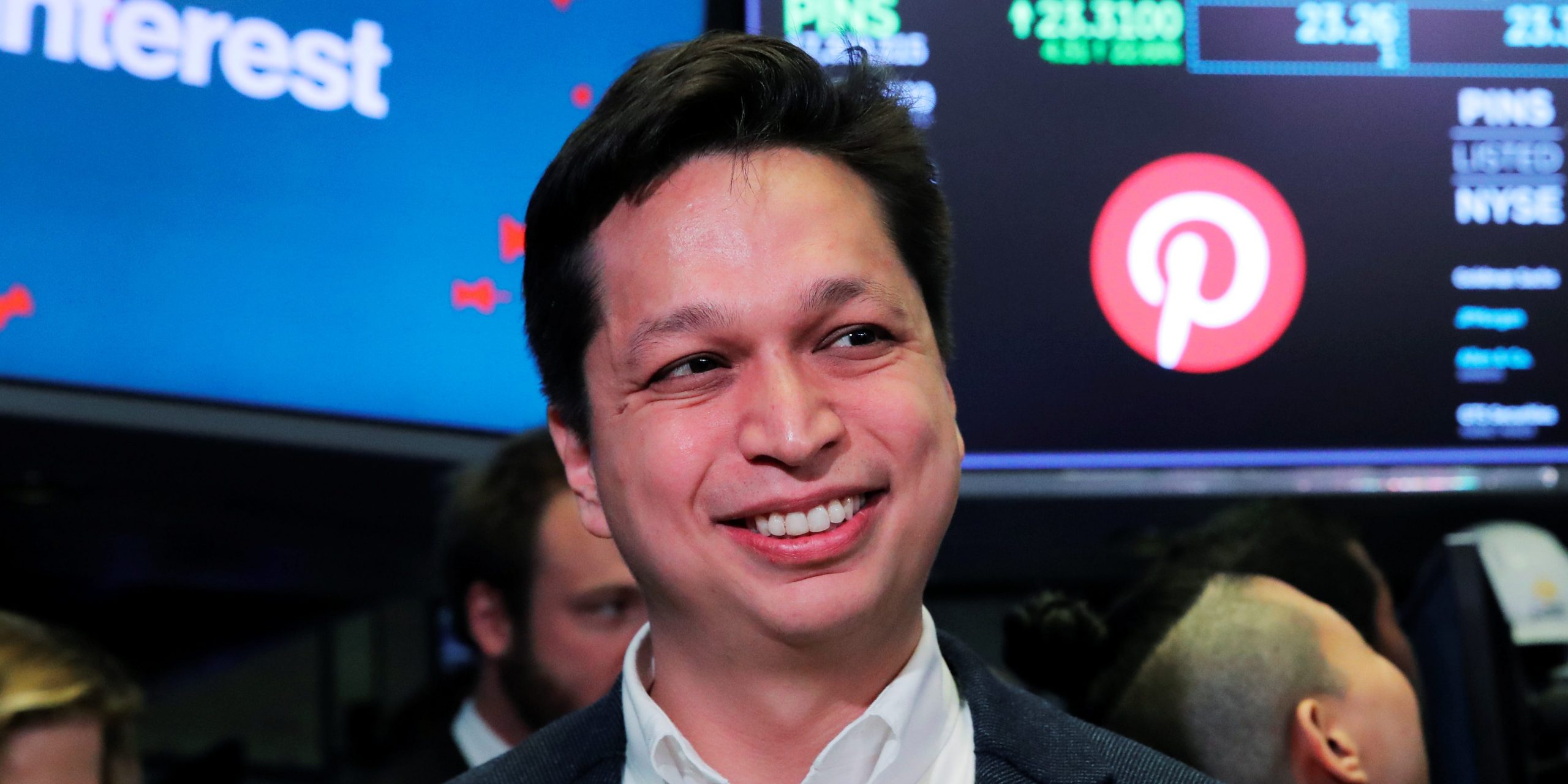A headshot of Pinterest CEO Ben Silbermann on the stock exchange floor in front of a sign with the pinterest logo