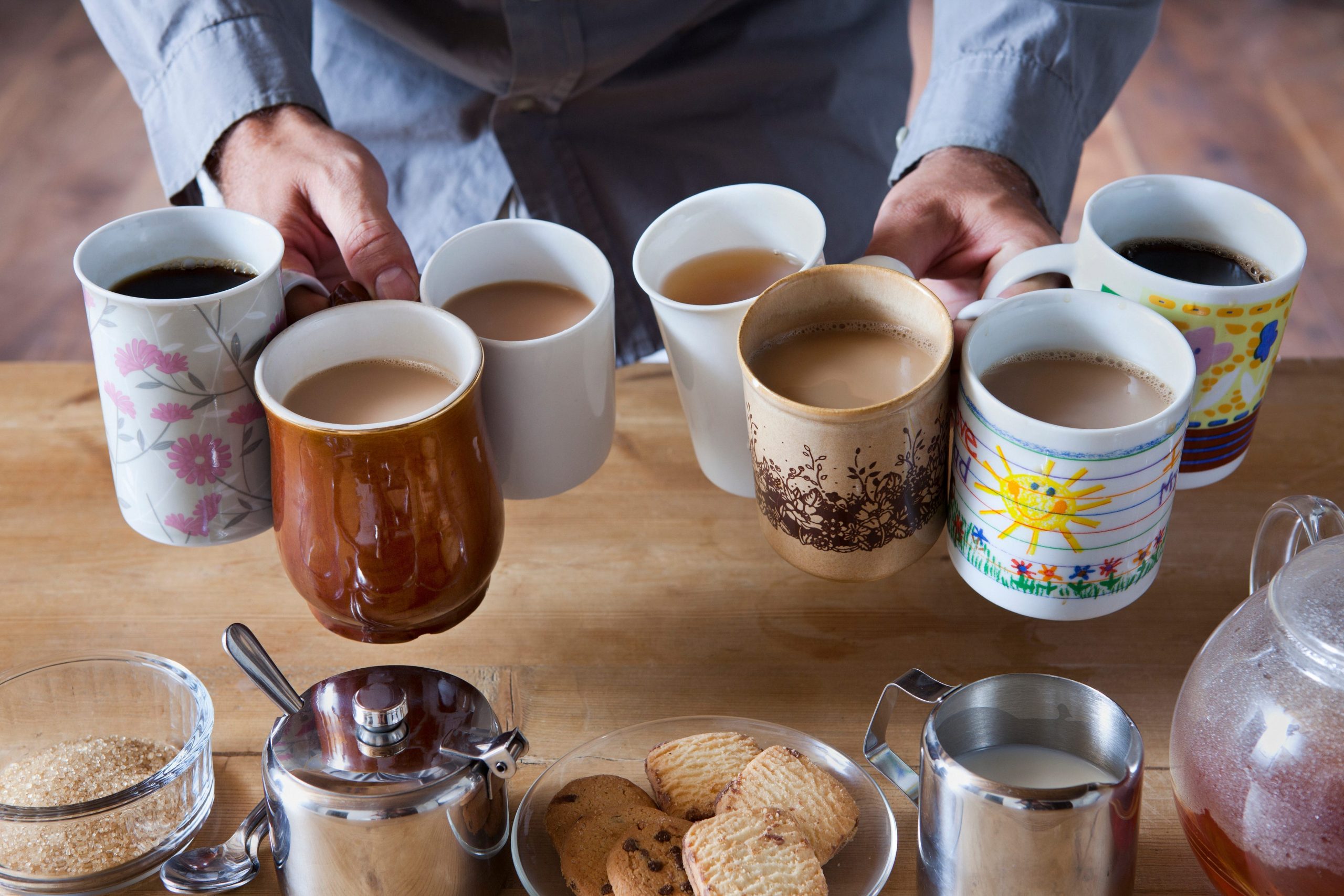 man holding several cups of coffee