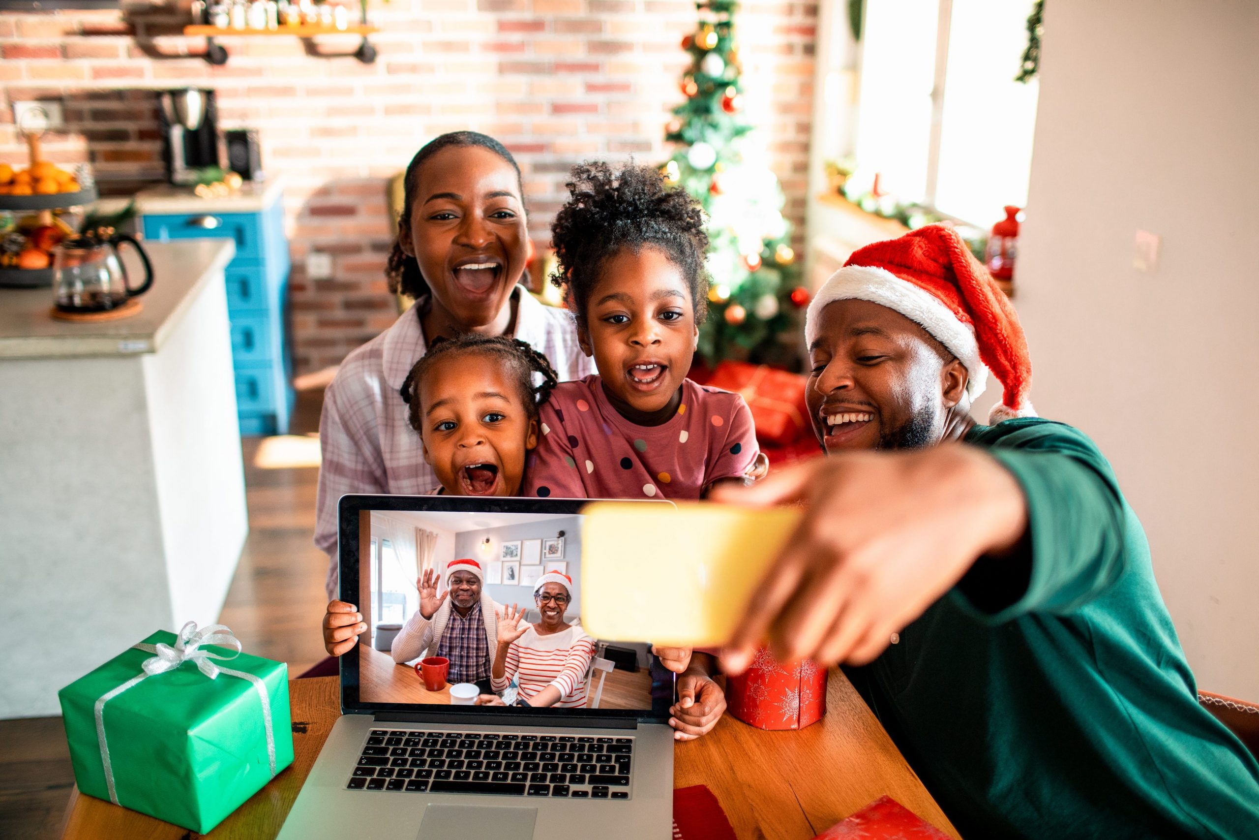 Family gathered around smart phone taking Christmas picture