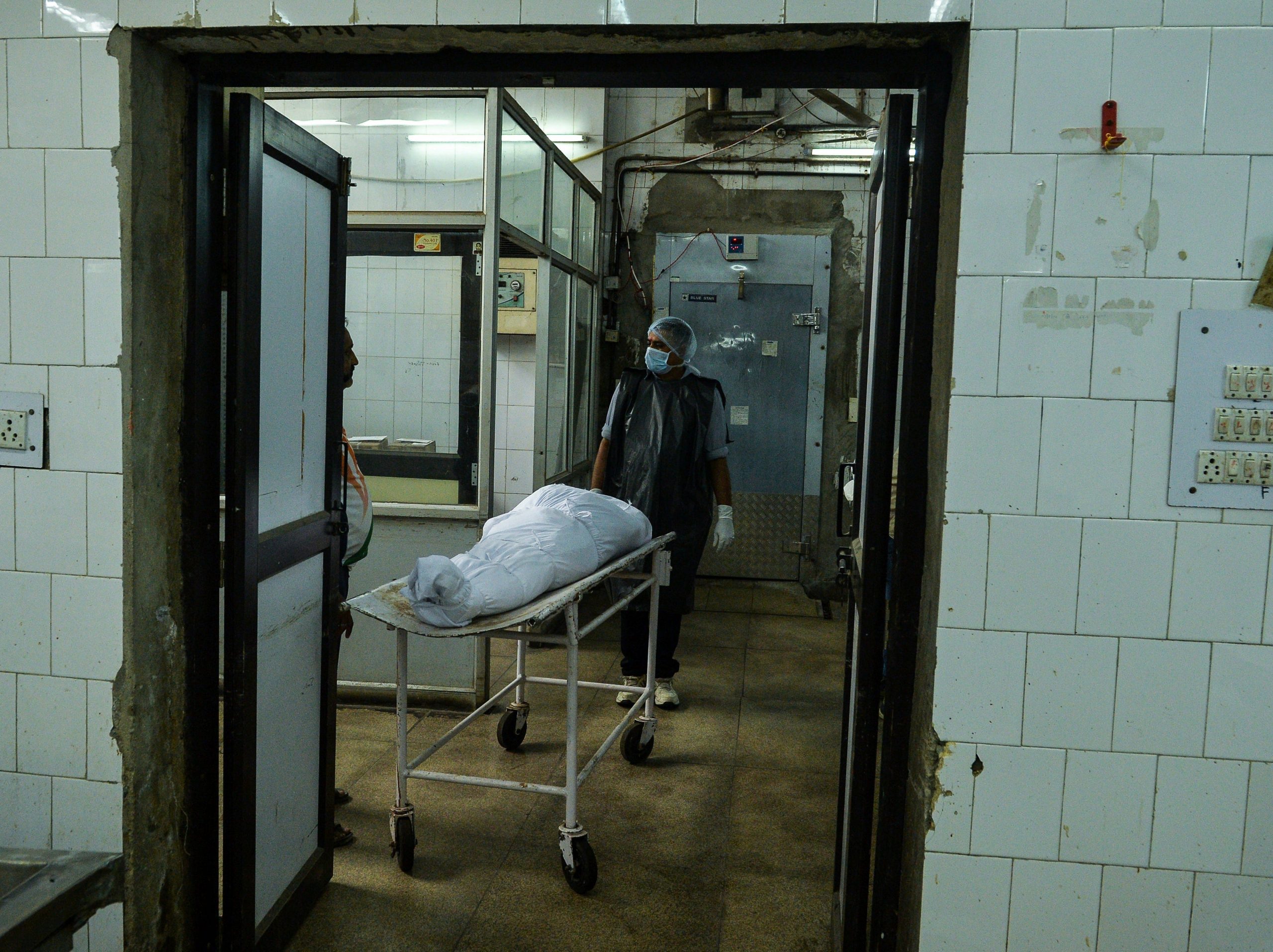 A morgue in New Delhi, where a body lies in a gurney.