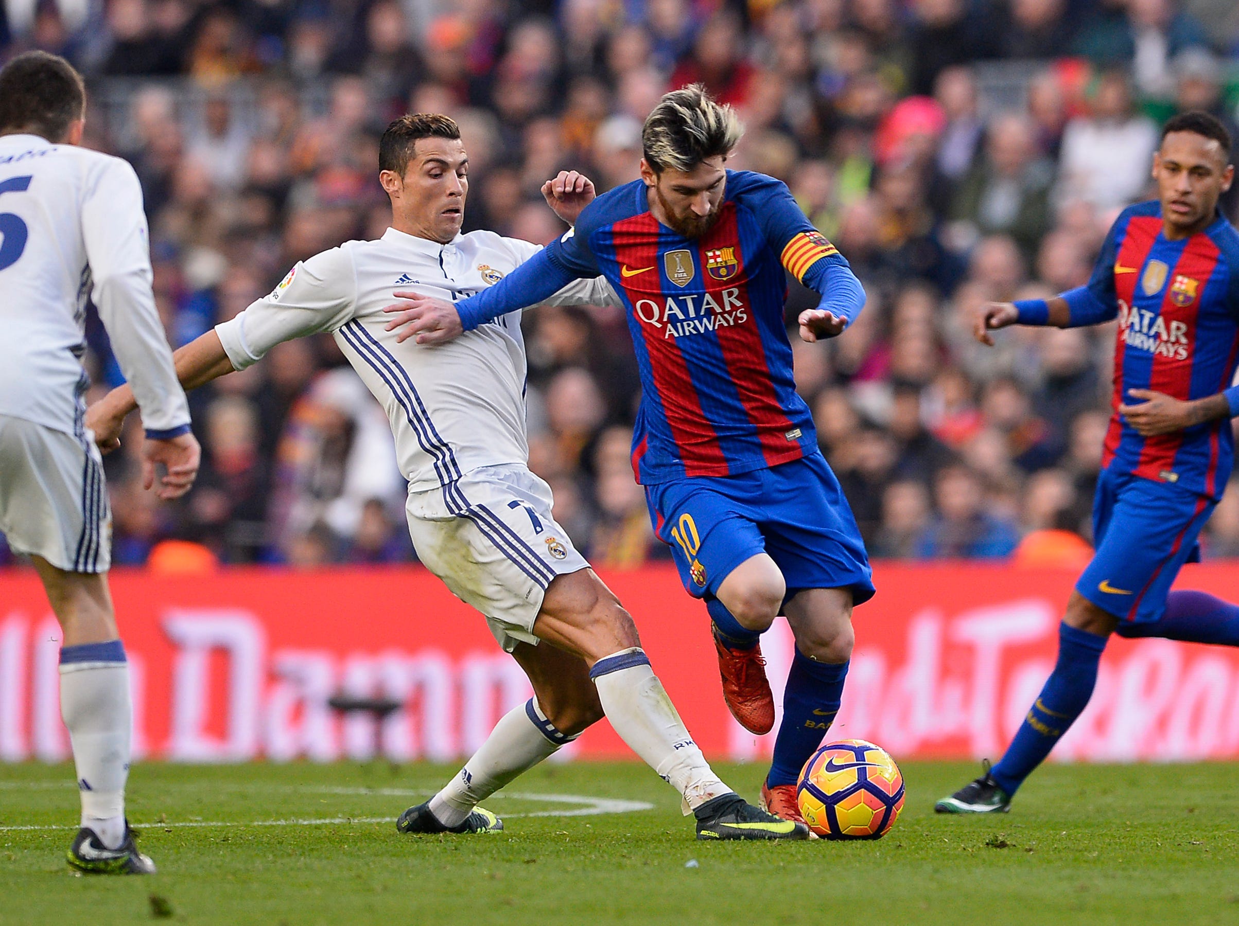 Cristiano Ronaldo tries to tackle Lionel Messi.