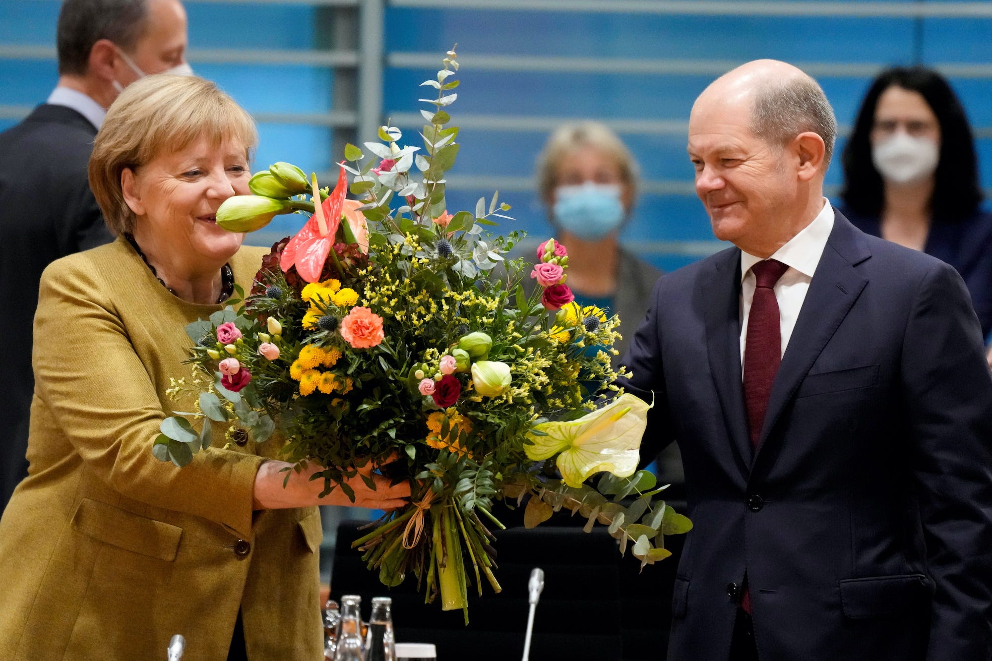 Angela Merkel smiles as she receives a bouquet of flowers