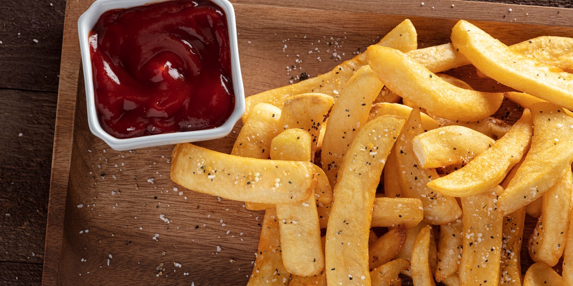 Directly above shot of seasoned french fries and ketchup on a table.