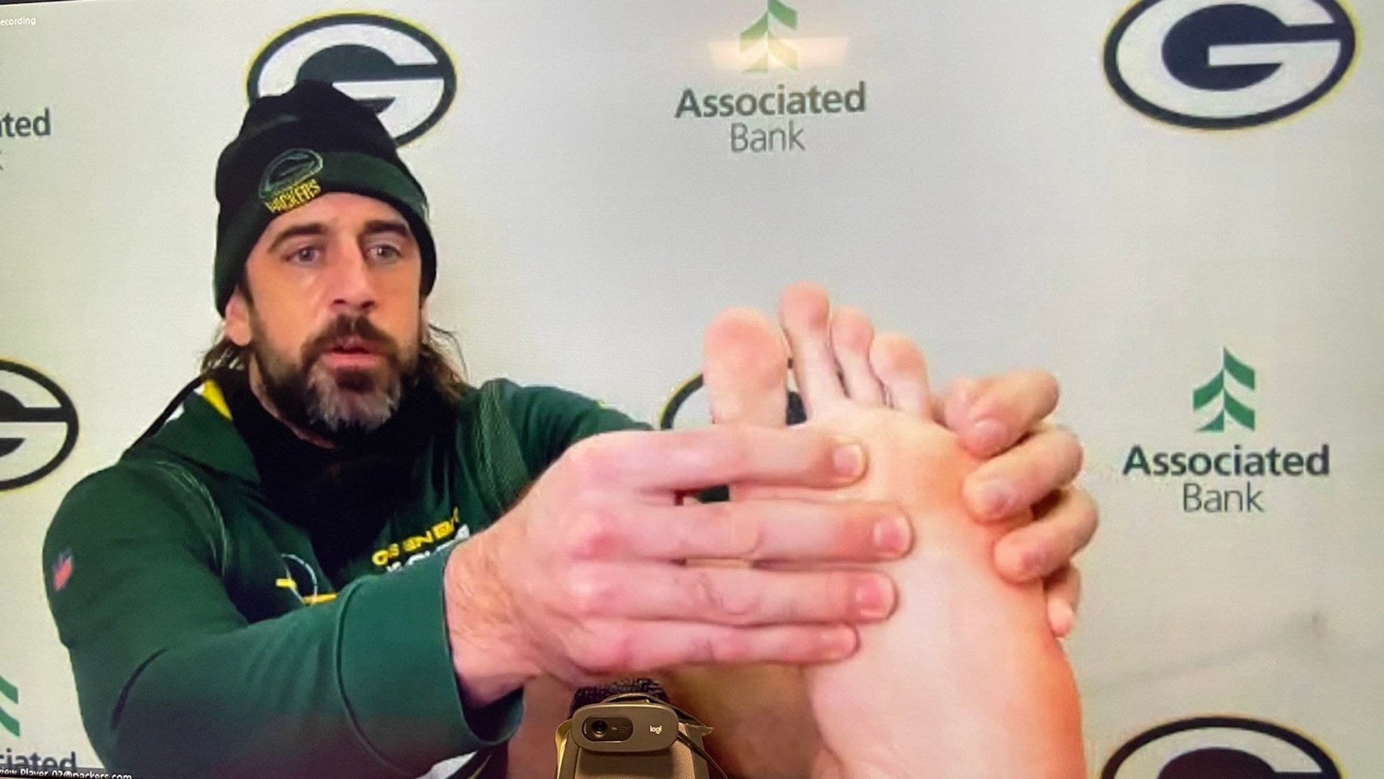 Aaron Rodgers shows his foot to reporters