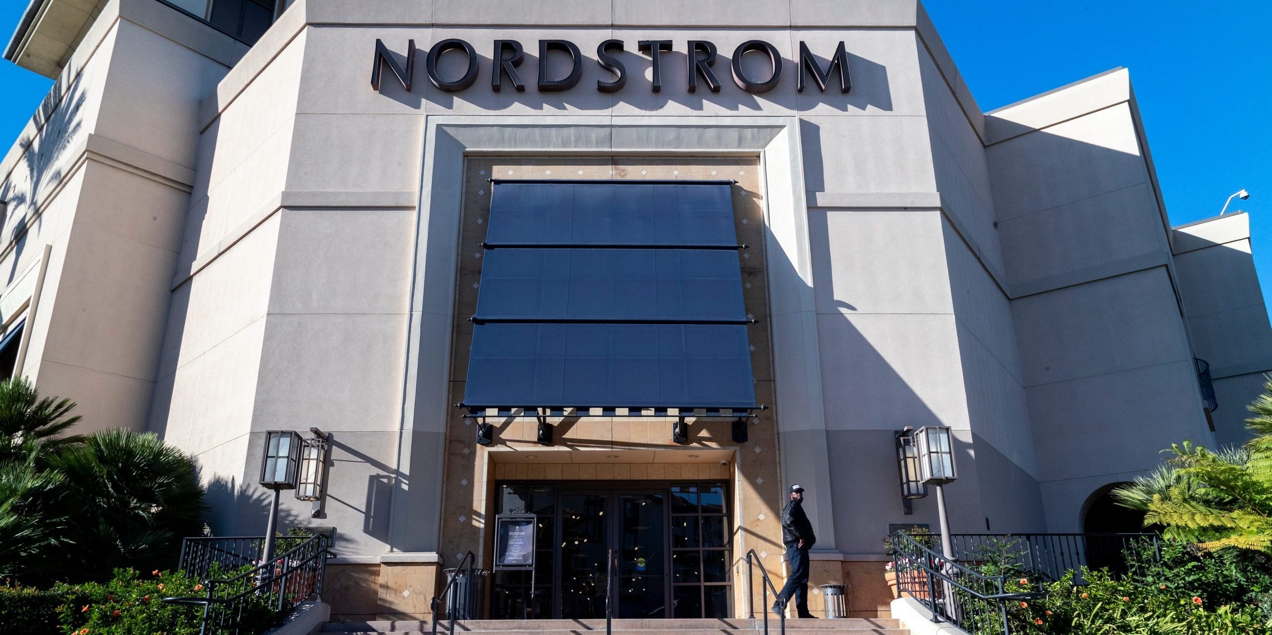 A security guard patrols the front entrance of Nordstrom on Tuesday after an organized group of thieves attempted a smash-and-grab robbery late Monday night at The Grove location November 23, 20201 in Los Angeles, California.