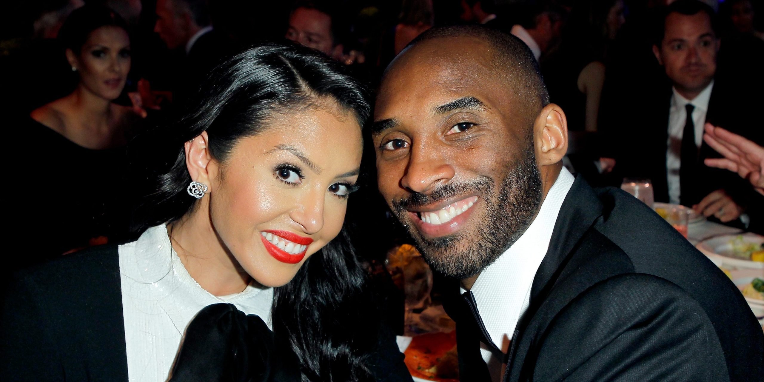 Vanessa Bryant (left) and Kobe Bryant (right) touching heads to pose for a photo in black and white attire