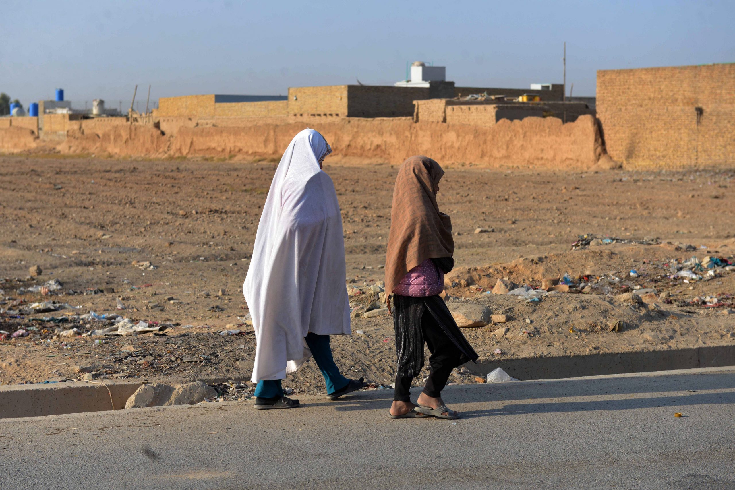 Afghan girls walk along a street to go to their school in Kandahar on November 6, 2021.