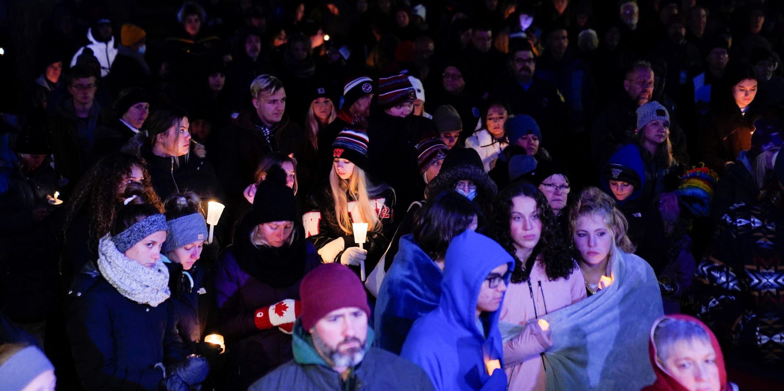 Community members mourn during a candle light vigil after a car plowed through a holiday parade in Waukesha, Wisconsin