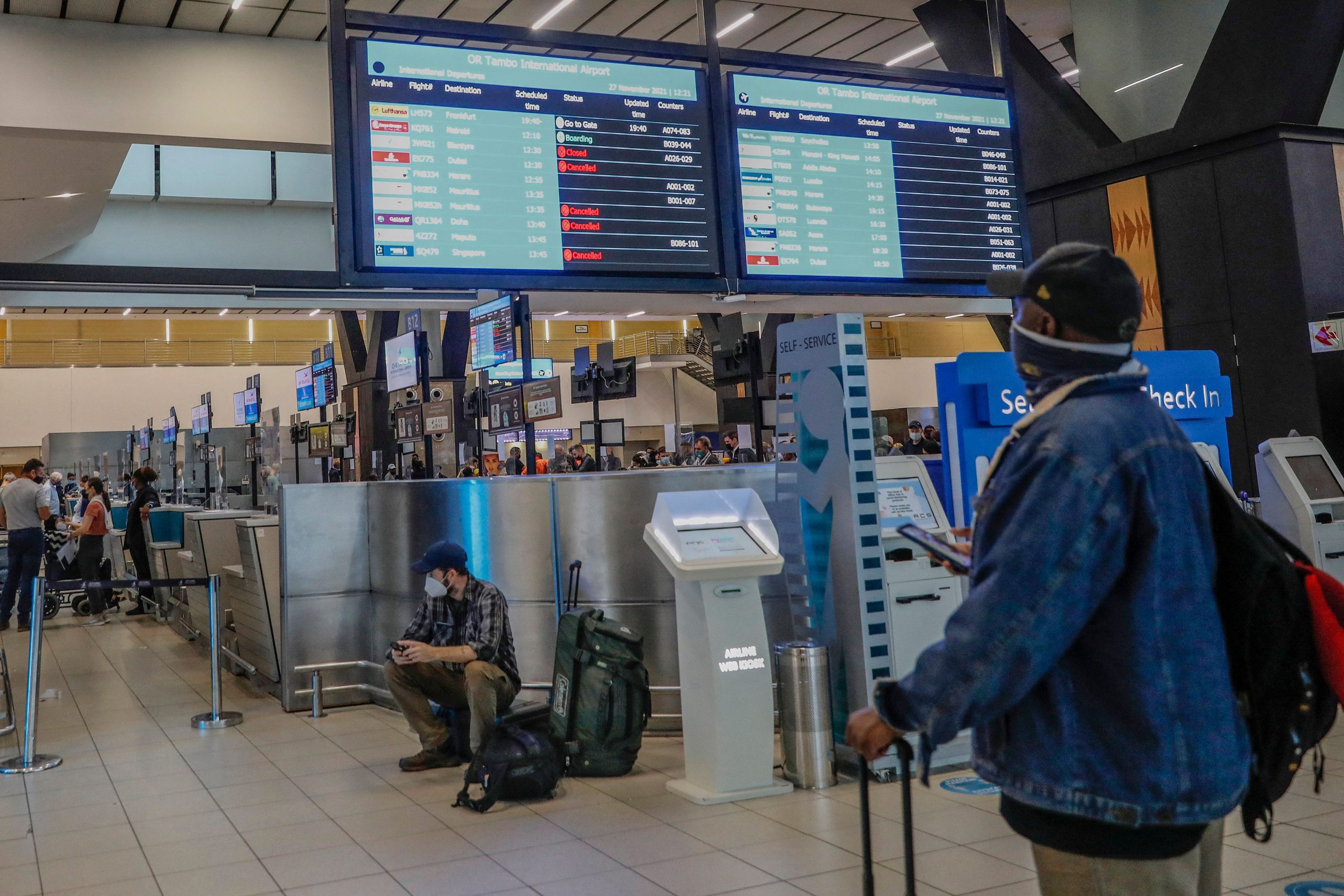 A passenger looks at an electronic flight notice board displaying cancelled flights at Tambo International Airport in Johannesburg on November 27, 2021, after several countries banned flights from South Africa following the discovery of a new coronavirus variant Omicron.