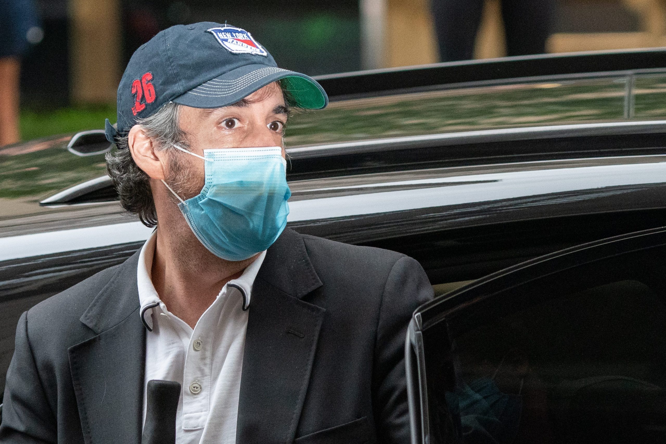 Michael Cohen exits a car while wearing a mask