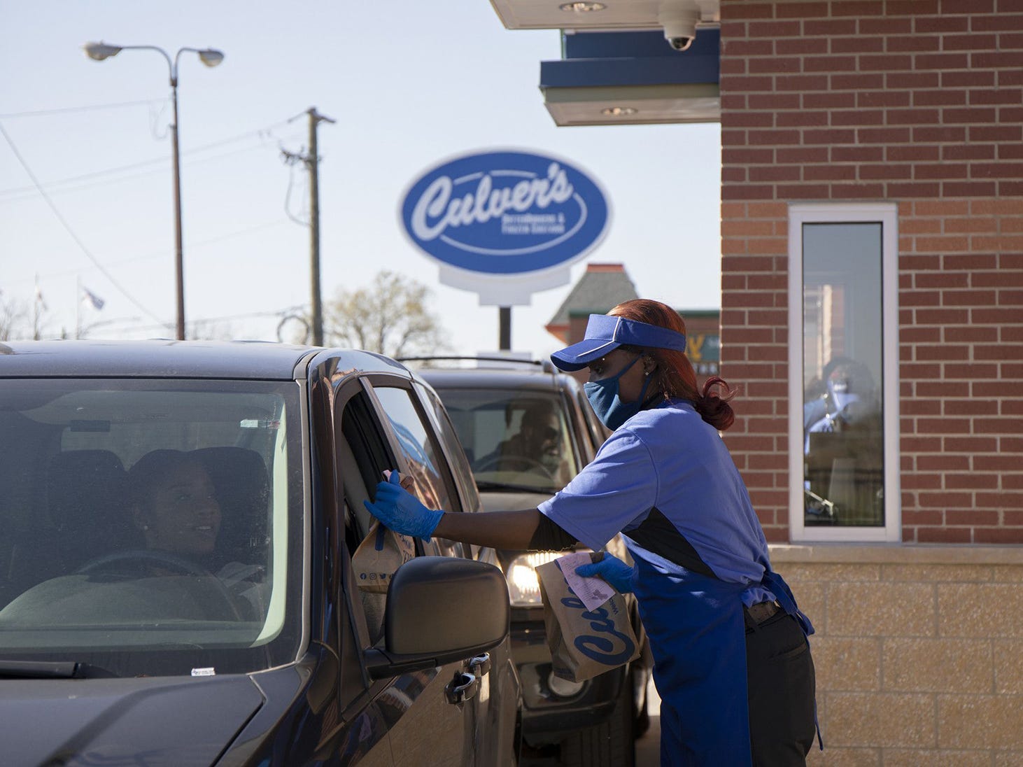 Culver's employee Teesha Nelson hands a drive-thru customer their order on Nov. 8, 2021, outside the restaurant chain;s newest location in Pullman on its opening day.