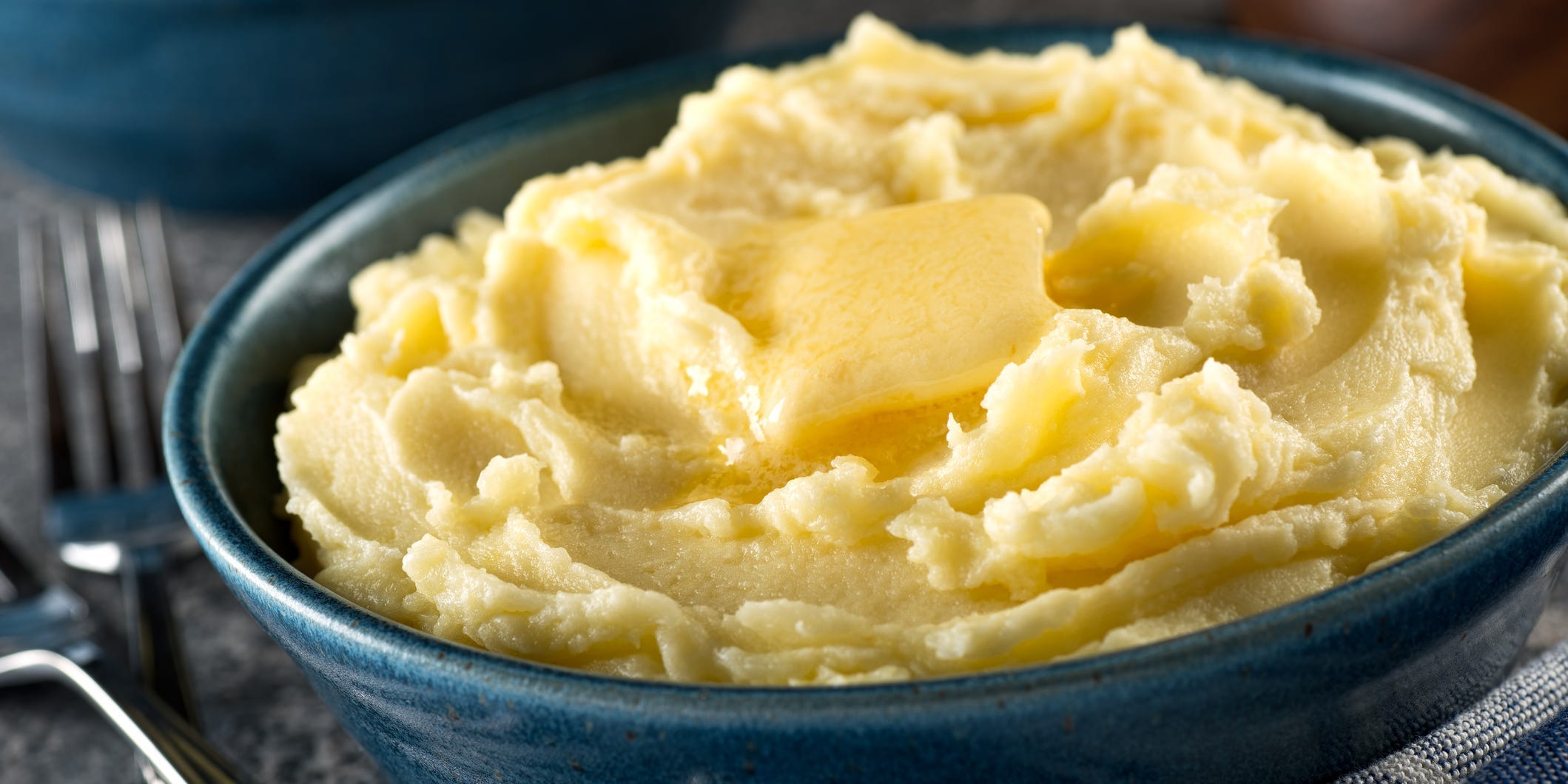 A large bowl of mashed potatoes topped with butter