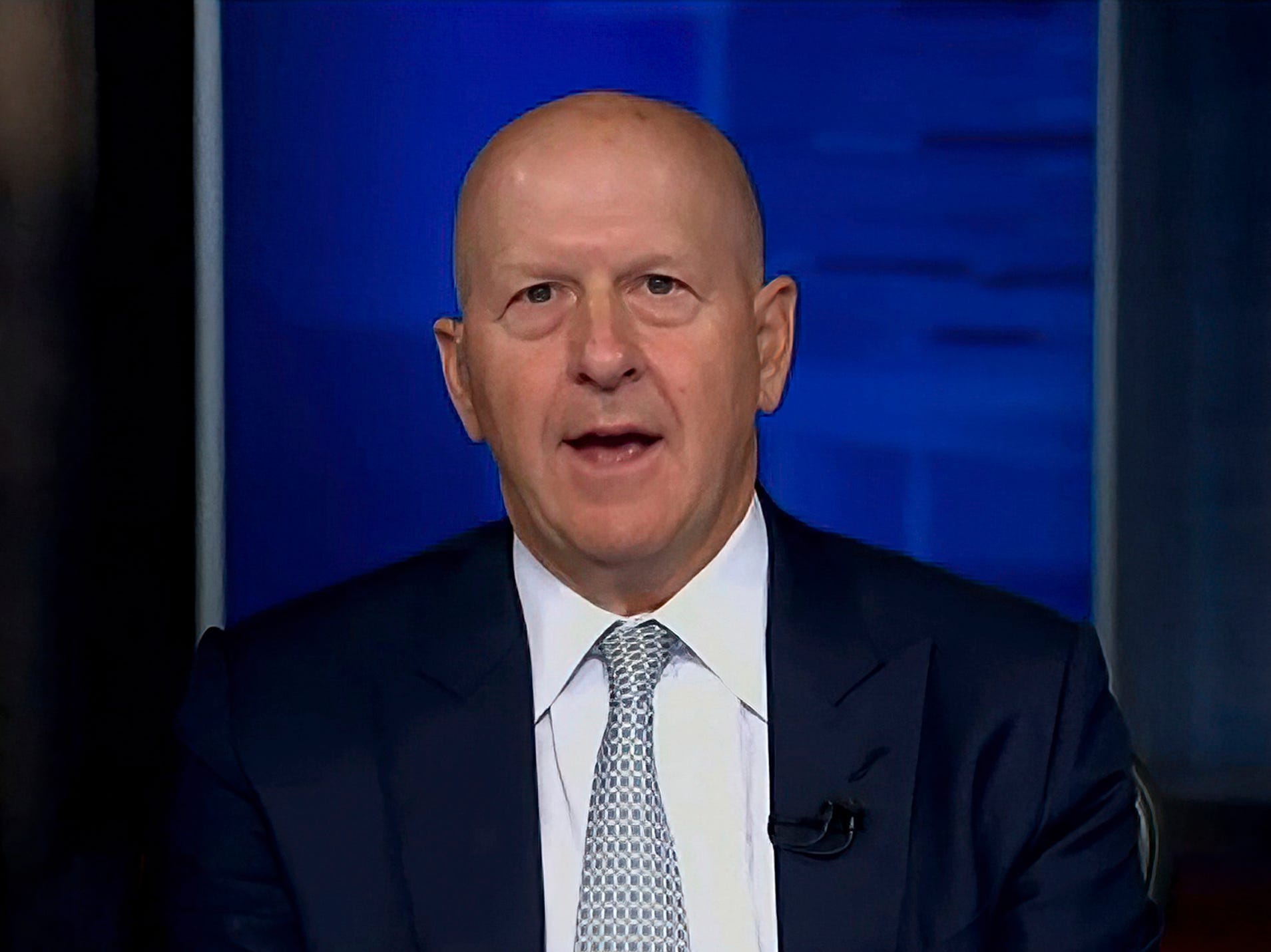 Goldman Sachs chief David Solomon speaks in front of a blue screen.