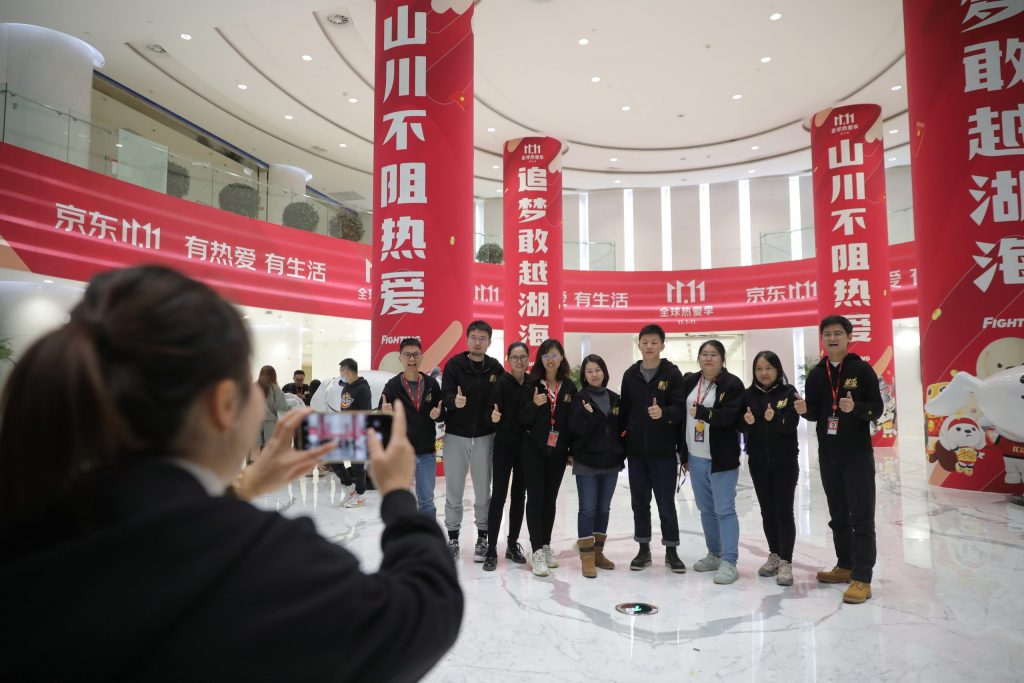 Werknemers van het Chinese e-commercebedrijf JD.com poseren maandag op het hoofdkantoor voor een foto.