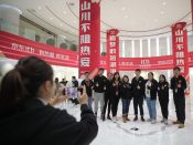 Werknemers van het Chinese e-commercebedrijf JD.com poseren maandag op het hoofdkantoor voor een foto.