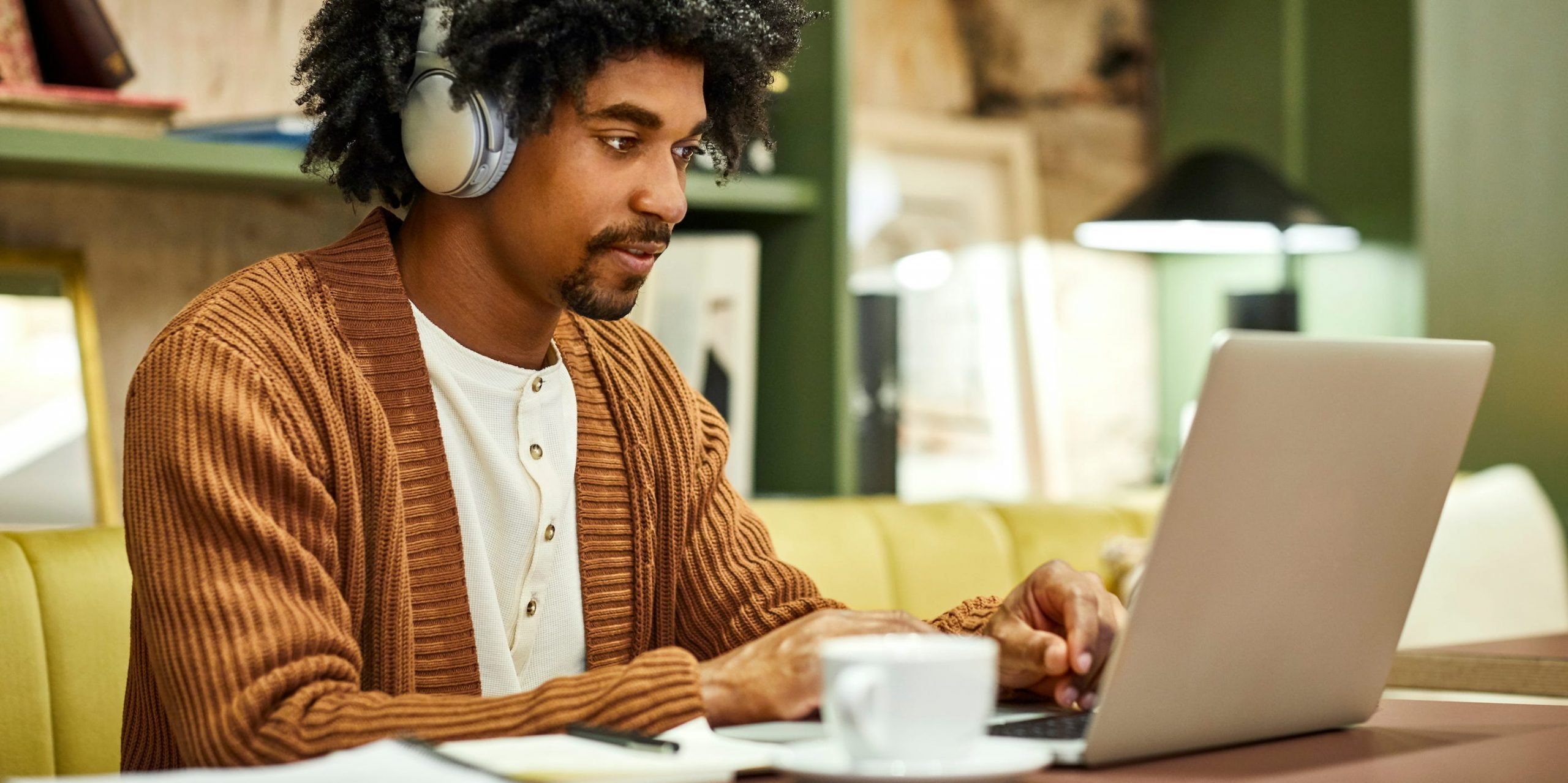 young man using laptop computer at home headphones