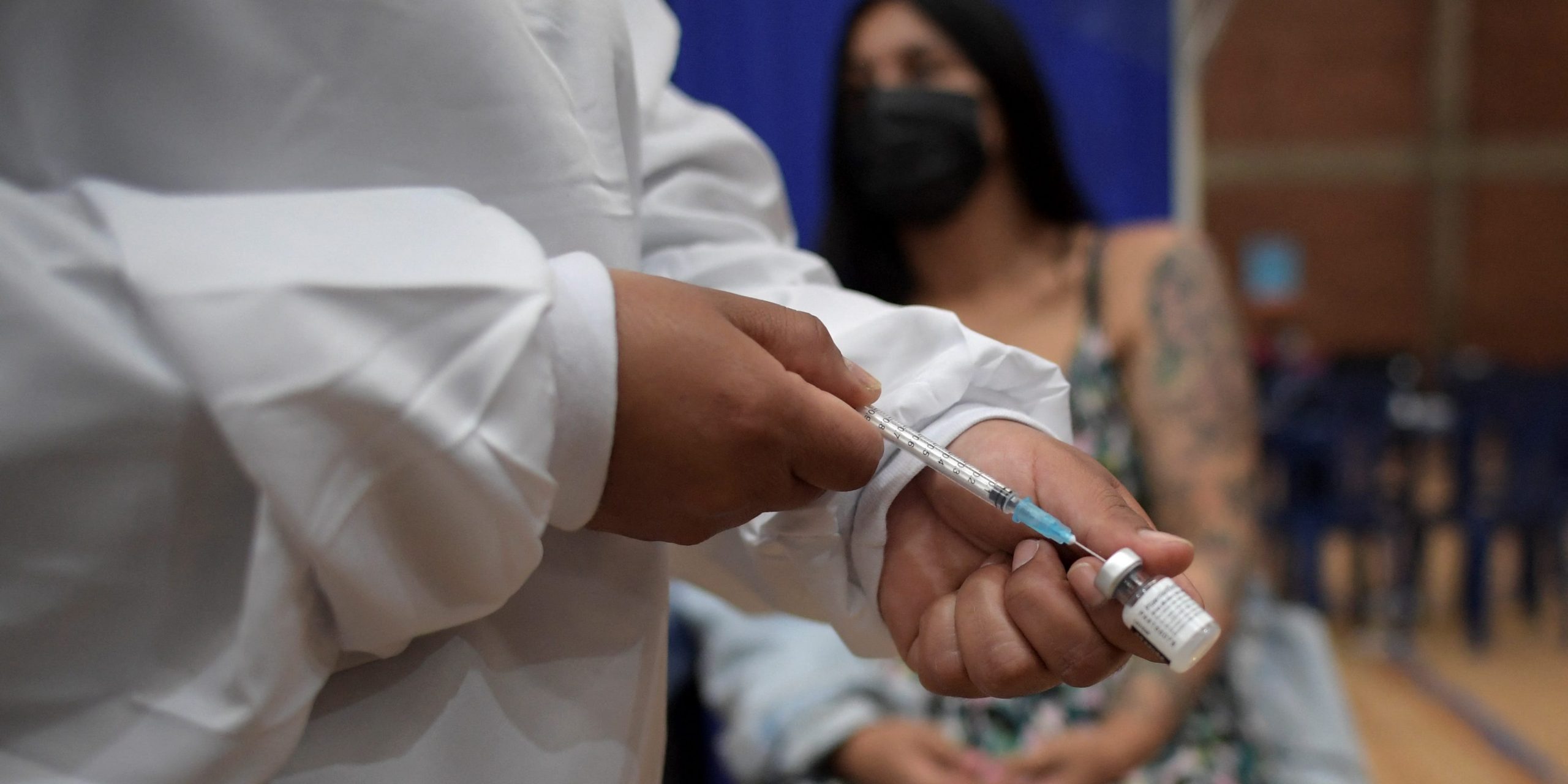 A health worker prepares to inoculate a pregnant woman with the Pfizer-BioNTech vaccine against COVID-19 at a vaccination center in Bogota.