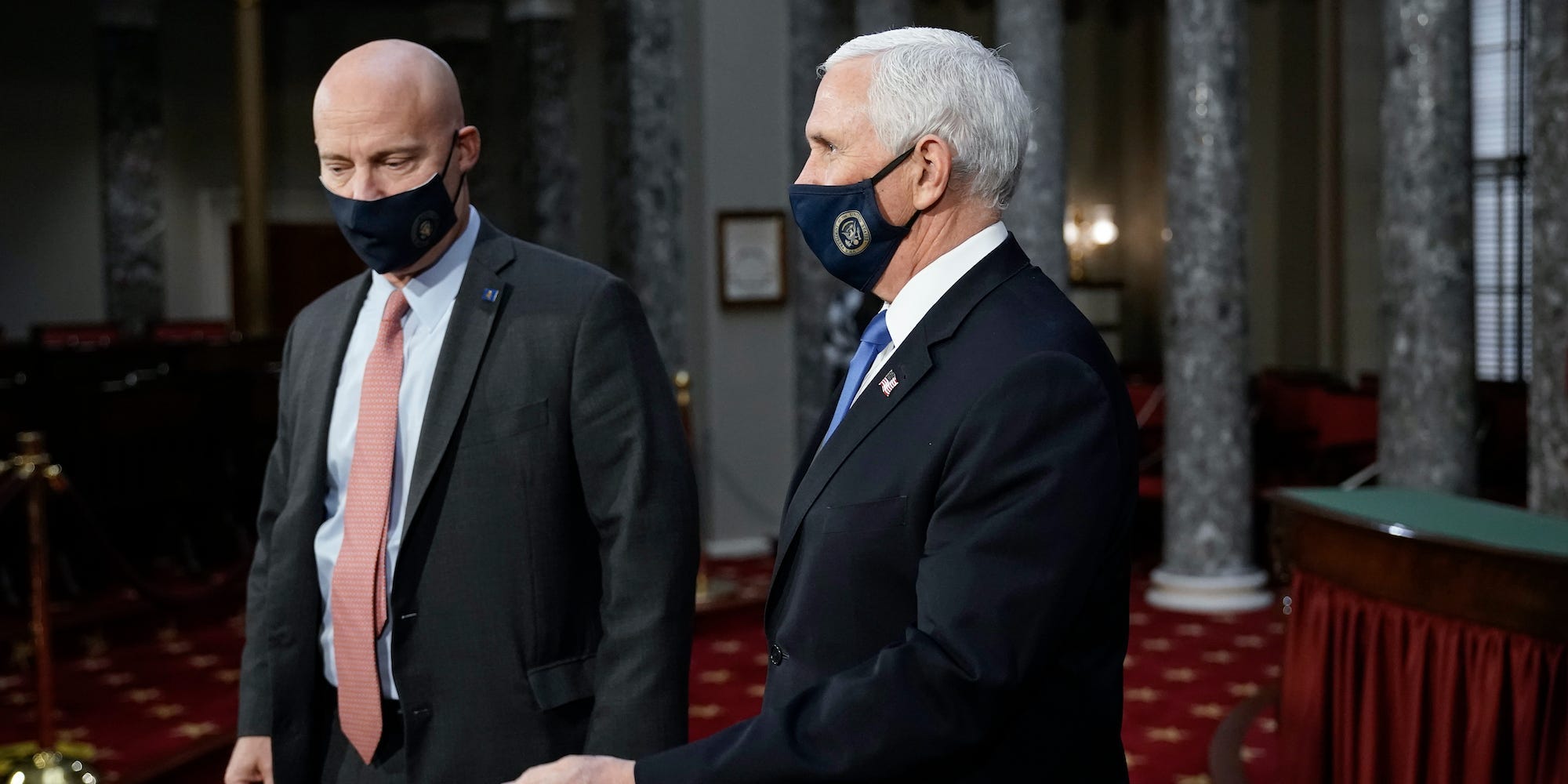 Vice President Mike Pence, joined at left by chief of staff Marc Short, finishes a swearing-in ceremony for senators in the Old Senate Chamber at the Capitol in Washington, Sunday, Jan. 3, 2021.