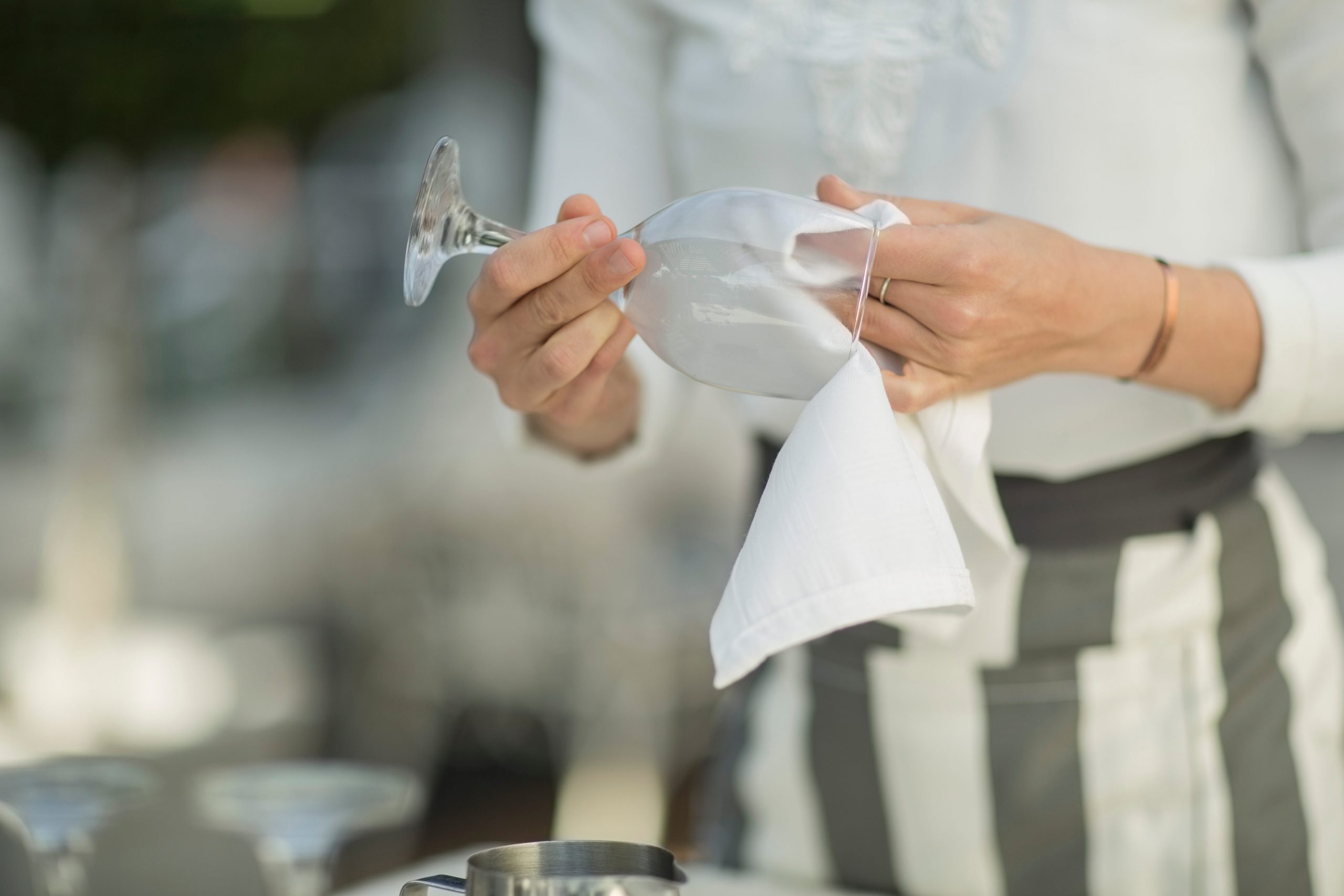 A waitress cleans a glass