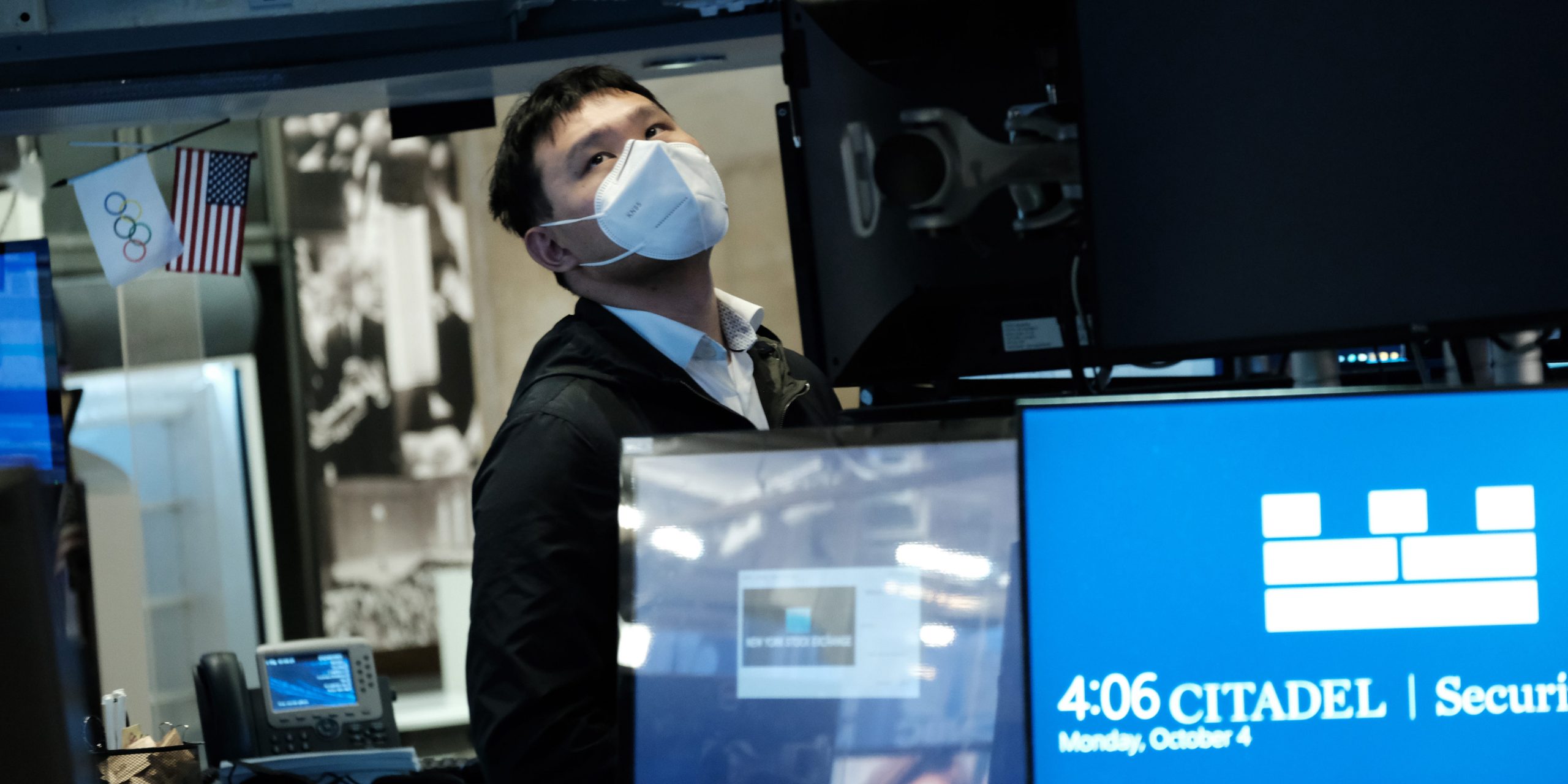 A trader wearing a mask works on the floor of the New York Stock Exchange