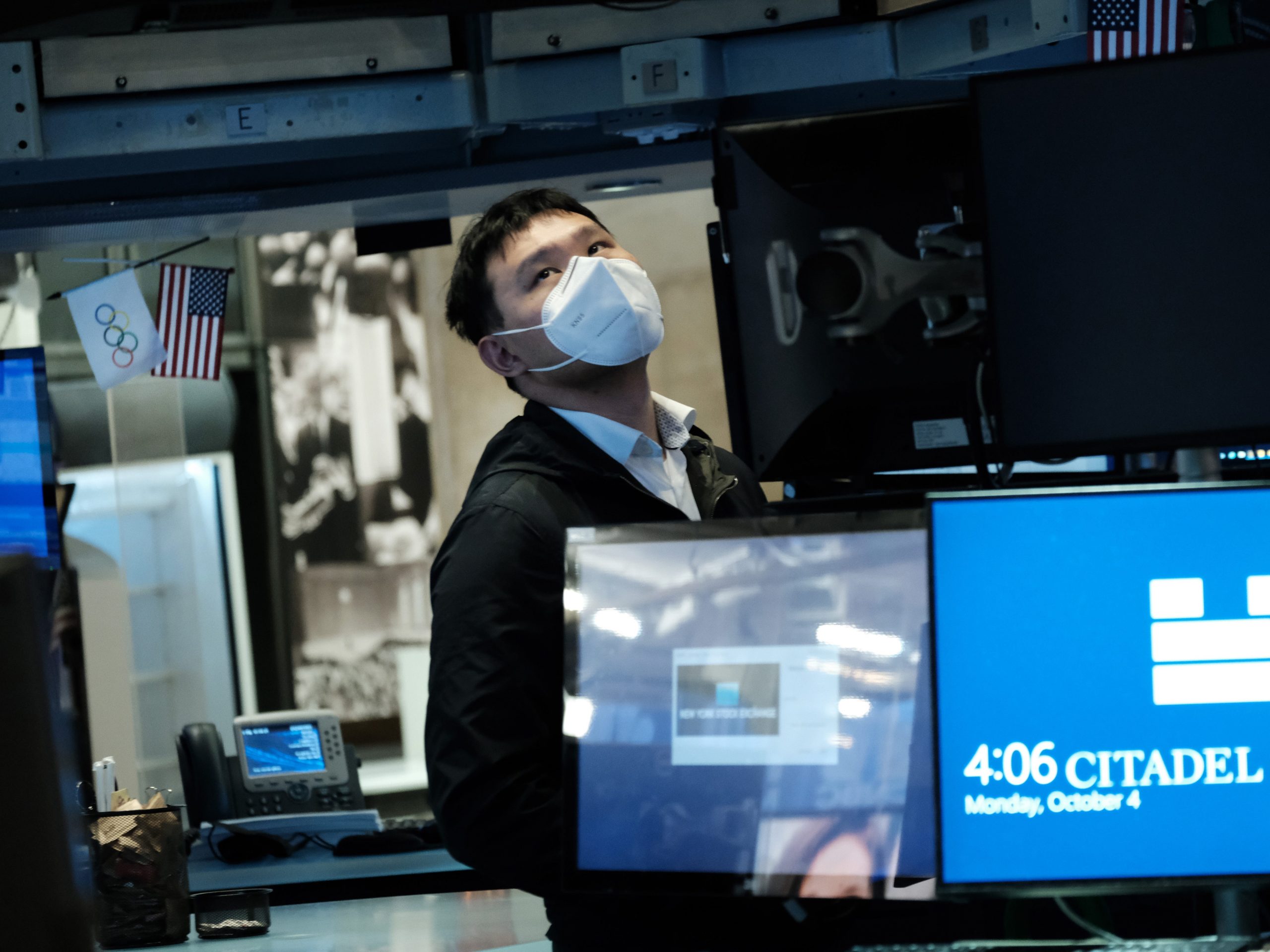 A trader wearing a mask works on the floor of the New York Stock Exchange