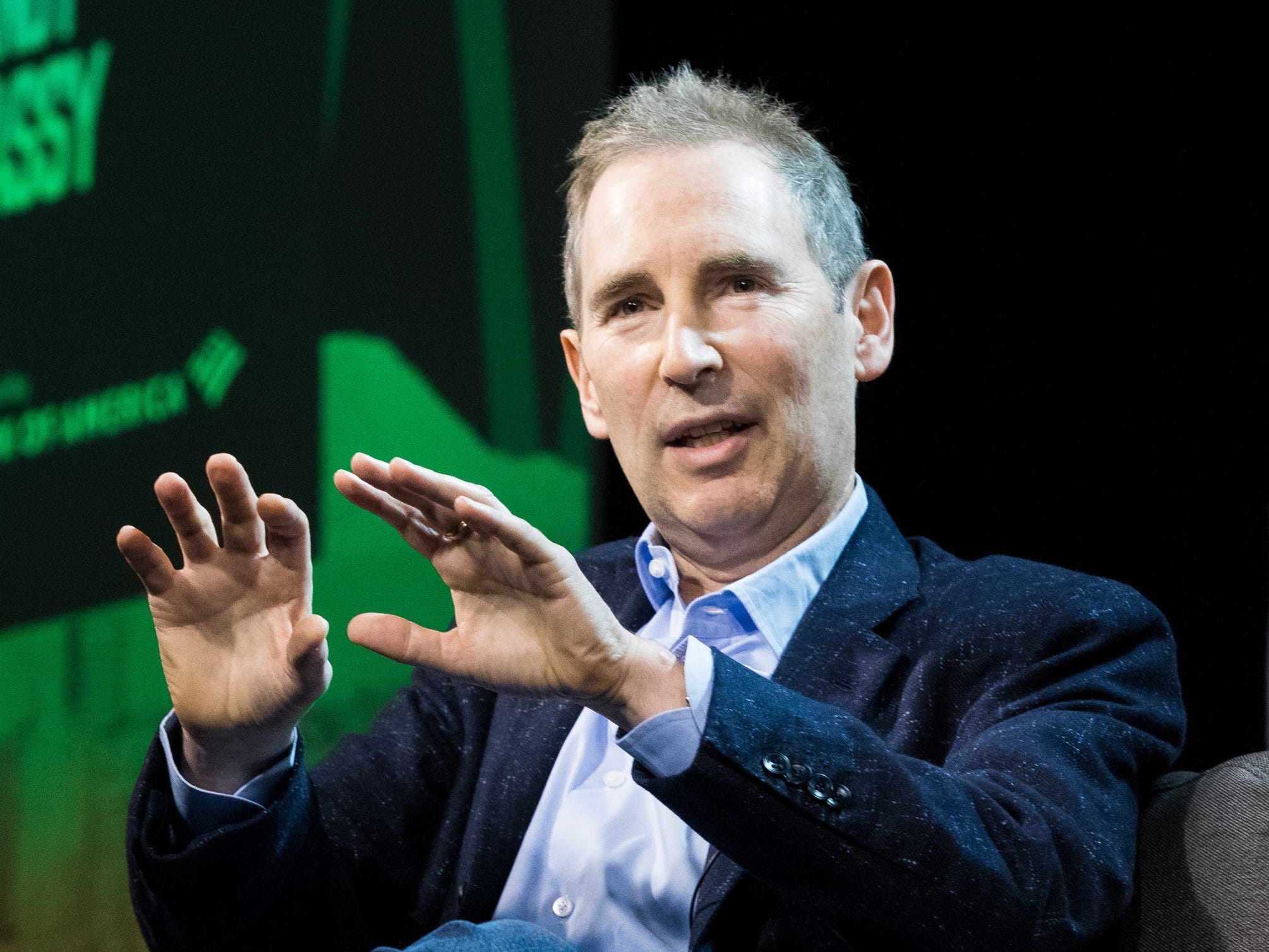 Amazon CEO Andy Jassy motions with his hands on stage at the GeekWire Summit.