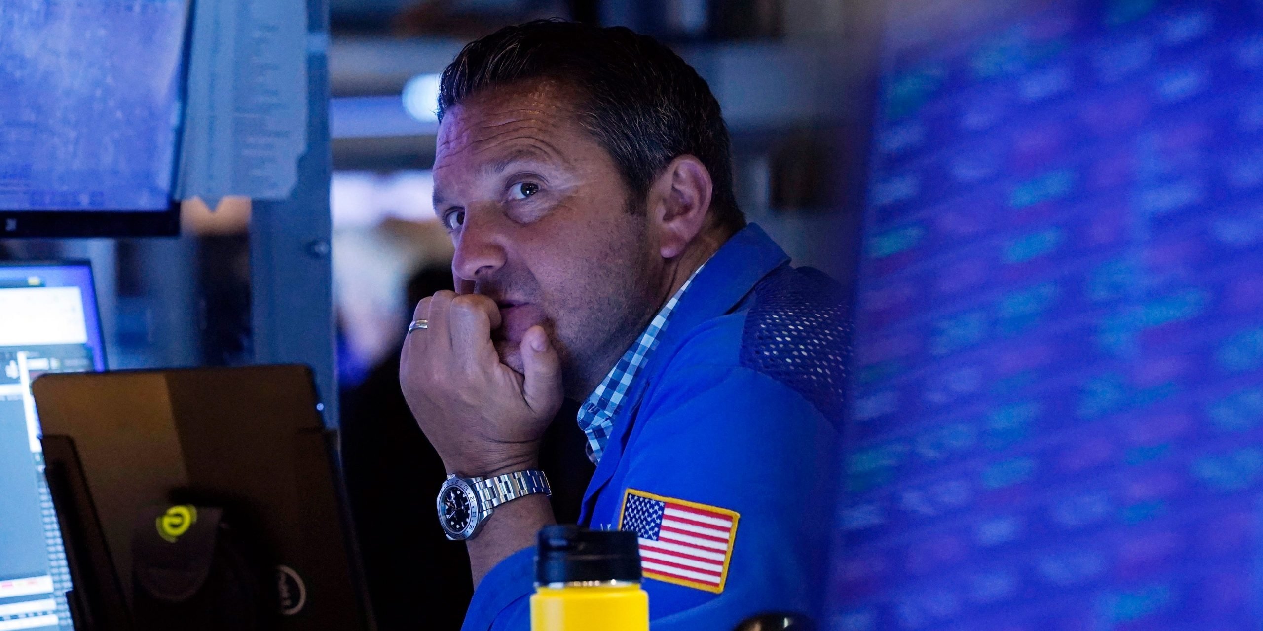 A trader sits in front of a computer monitor on the floor of the New York Stock Exchange.