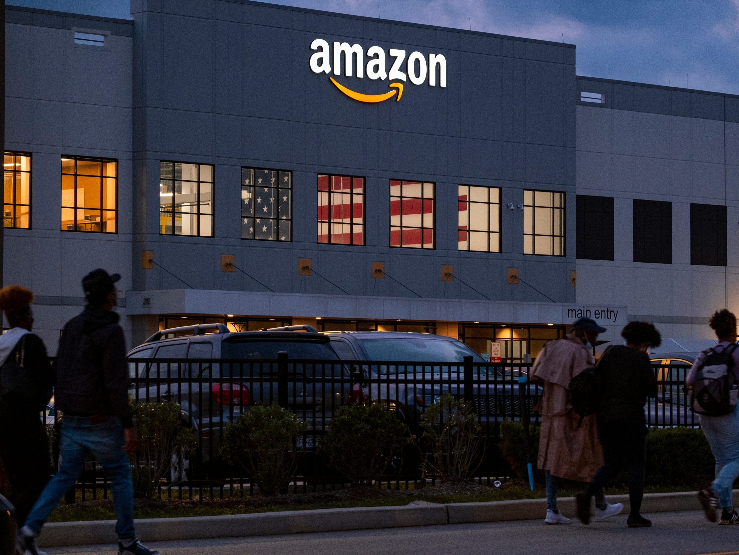 Workers arrive at an Amazon distribution center in the early morning