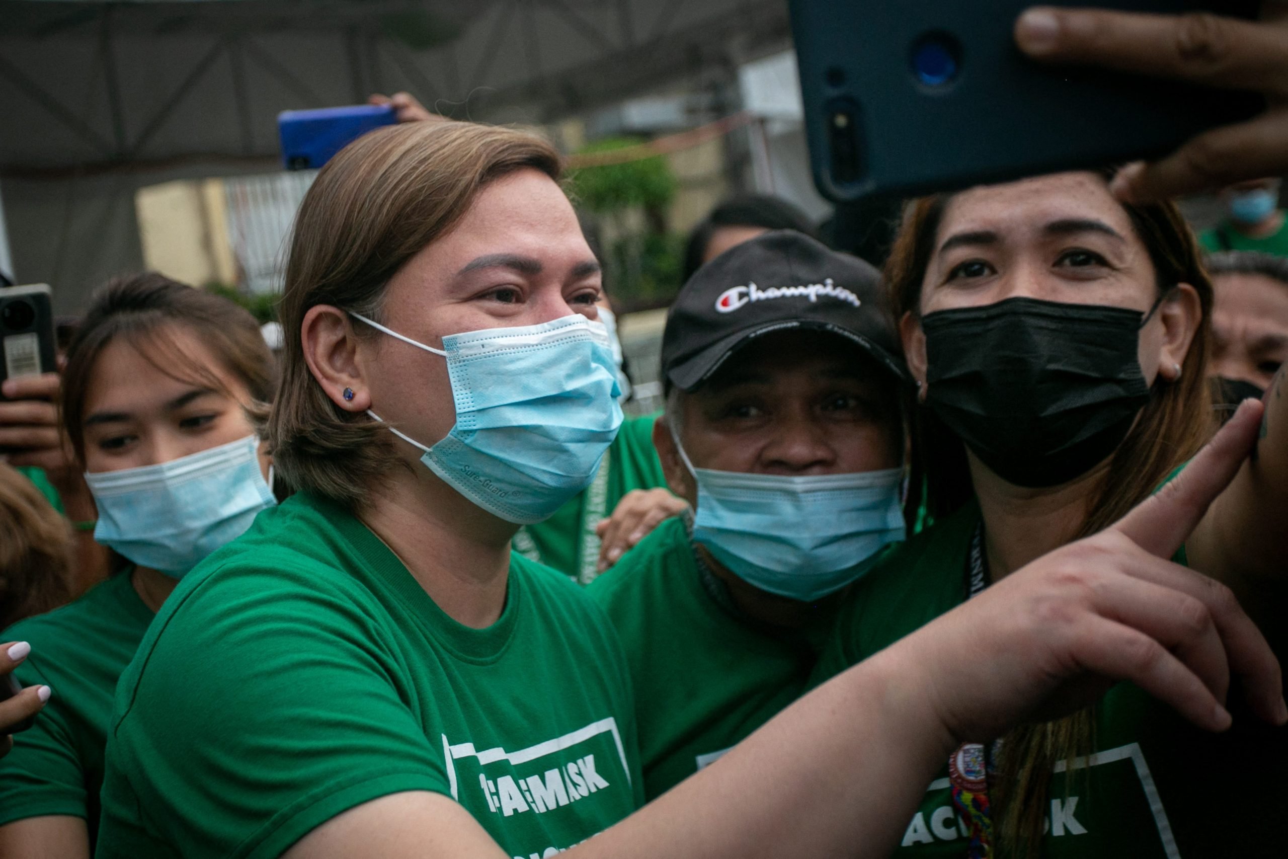 This photo taken on November 9, 2021 shows Sara Duterte (L), mayor and daughter of outgoing Philippines President Rodrigo Duterte, posing for a selfie with city hall employees in Davao city, on the southern island of Mindanao.